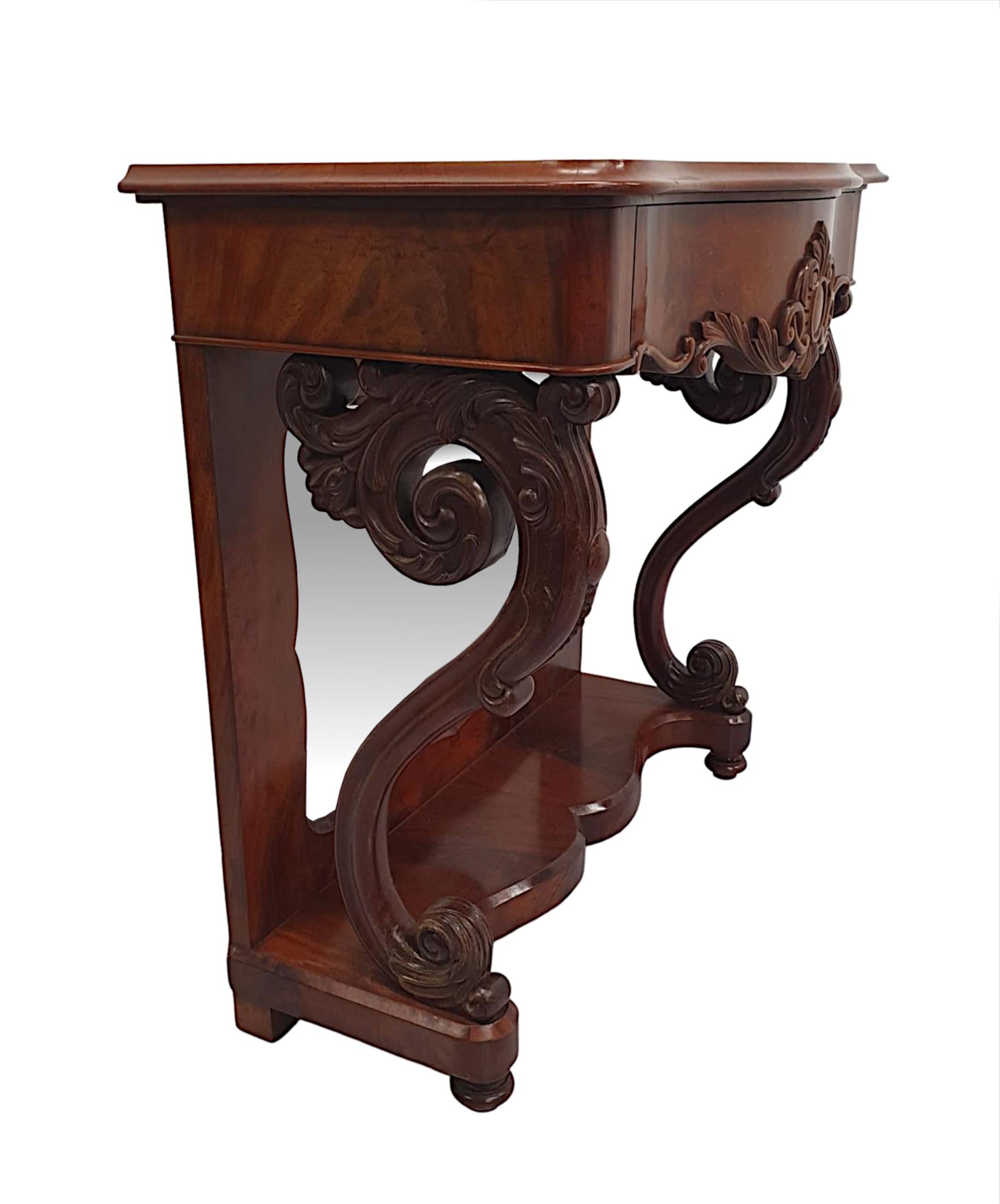 A very fine 19th Century flame mahogany mirror back console table, of gorgeous quality and finely hand carved with beautifully rich patination and grain.  The moulded serpentine top of rectangular form is raised over an elegantly simple single