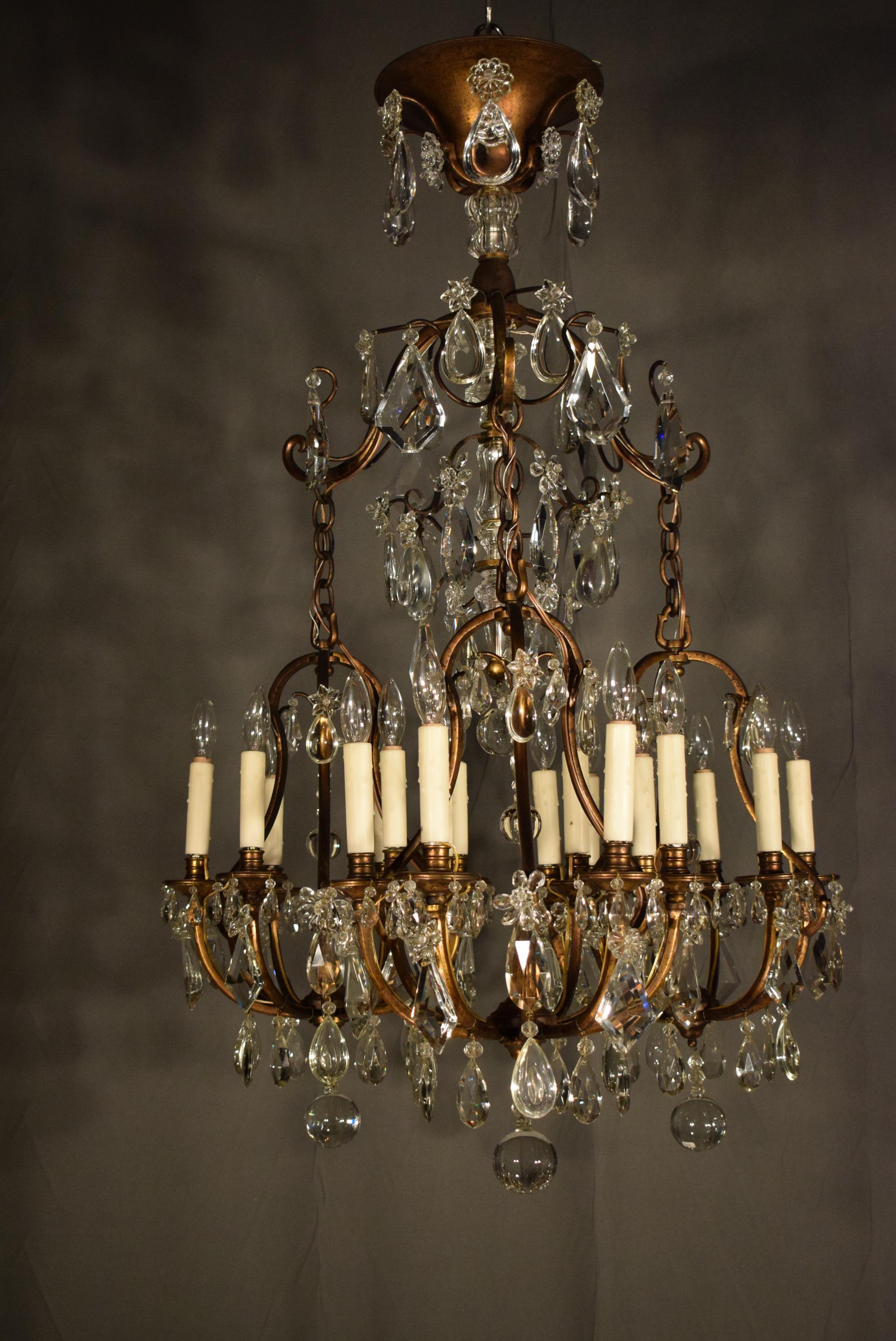 A very fine gilt bronze and crystal chandelier. Underneath the top canopy is a distribution box ( prolonged underneath by a shaft ) issuing three hooks, hanging from the hooks are chains ending in three identical six light 