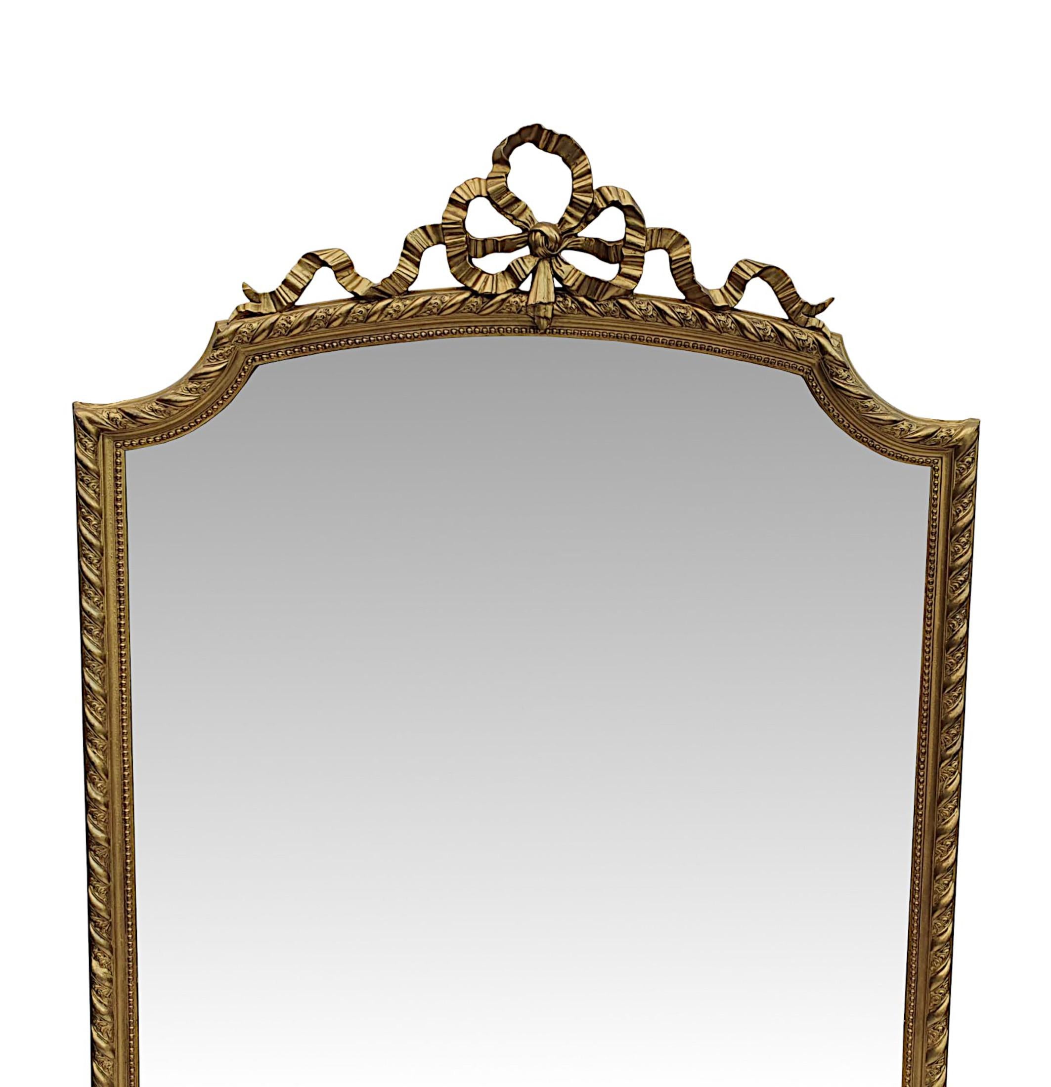 A very fine 19th Century giltwood leaner, hall or overmantle mirror of tall and narrow proportions. The slightly distressed, original bevelled mirror glass plate is set within a beautifully hand carved, moulded frame with foliate, ribbon and beaded