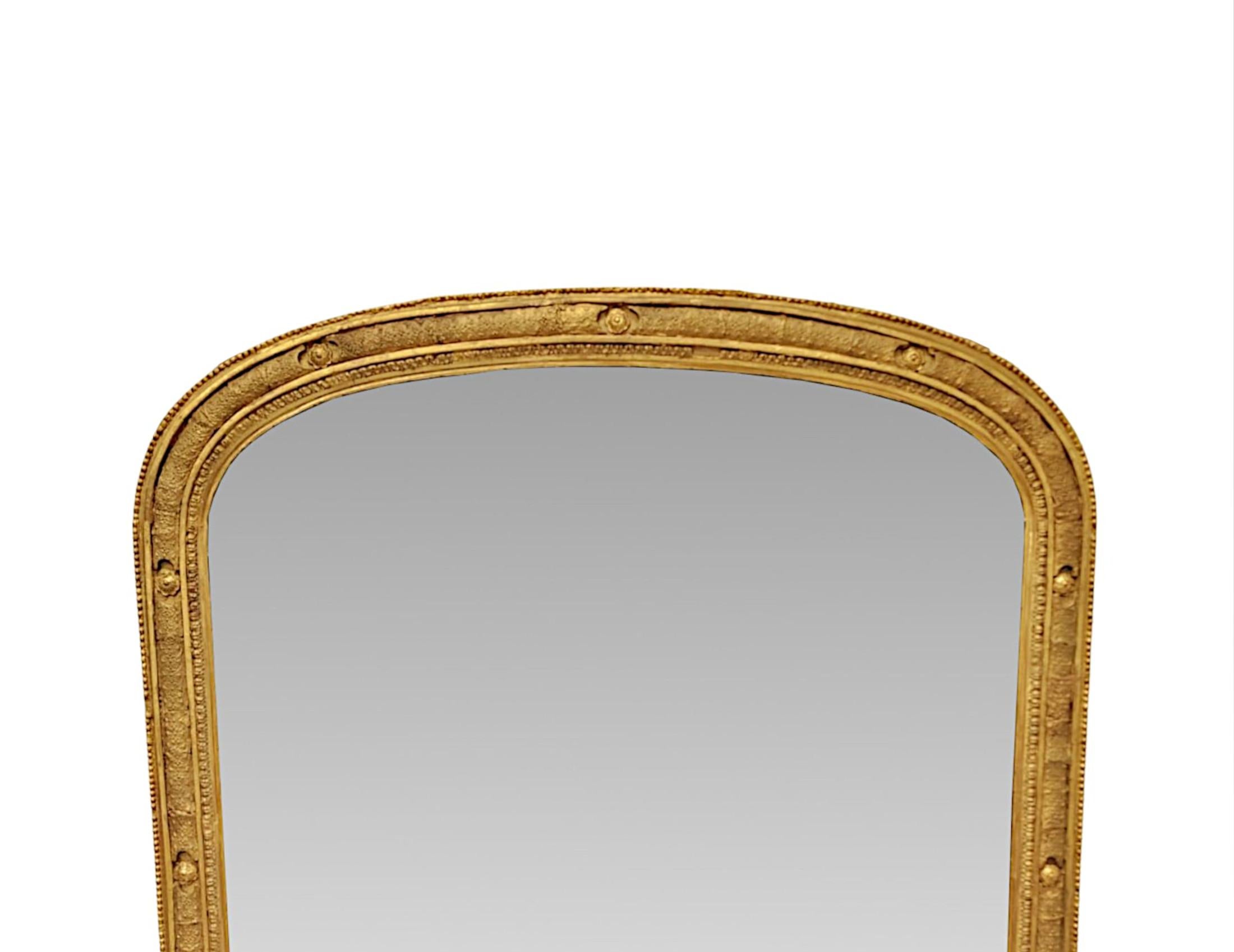A very fine 19th Century elegantly simple, giltwood overmantel mirror of exceptional quality and neat proportions.  The shaped mirror glass plate of archtop form is set within a stunningly hand carved, moulded and fluted giltwood frame with fabulous