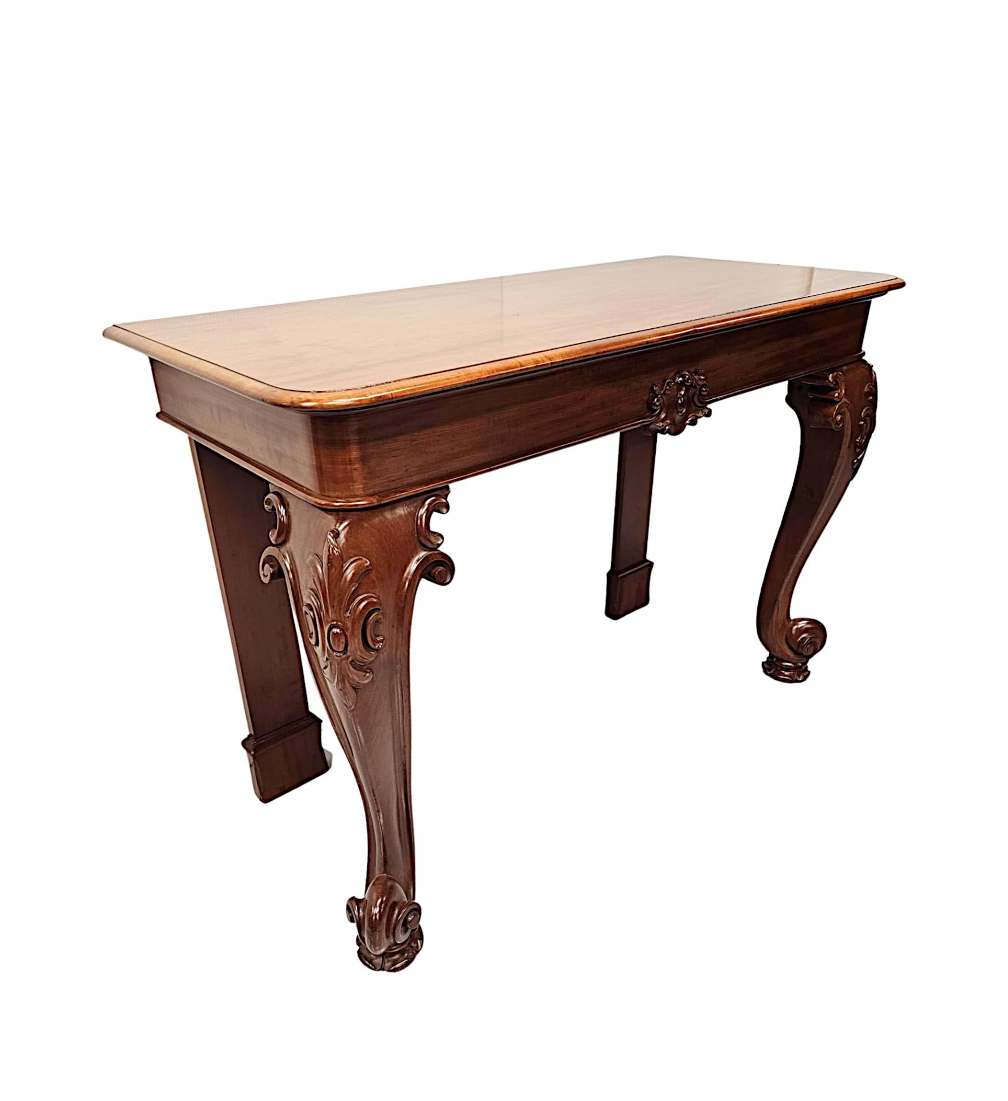 Très belle pièce du 19e siècle  Table console en acajou de fabuleuse qualité et étonnamment sculptée à la main avec une patine et un grain riches.  Le plateau bien figuré et mouluré de forme rectangulaire est surmonté d'une frise simple ornée d'un