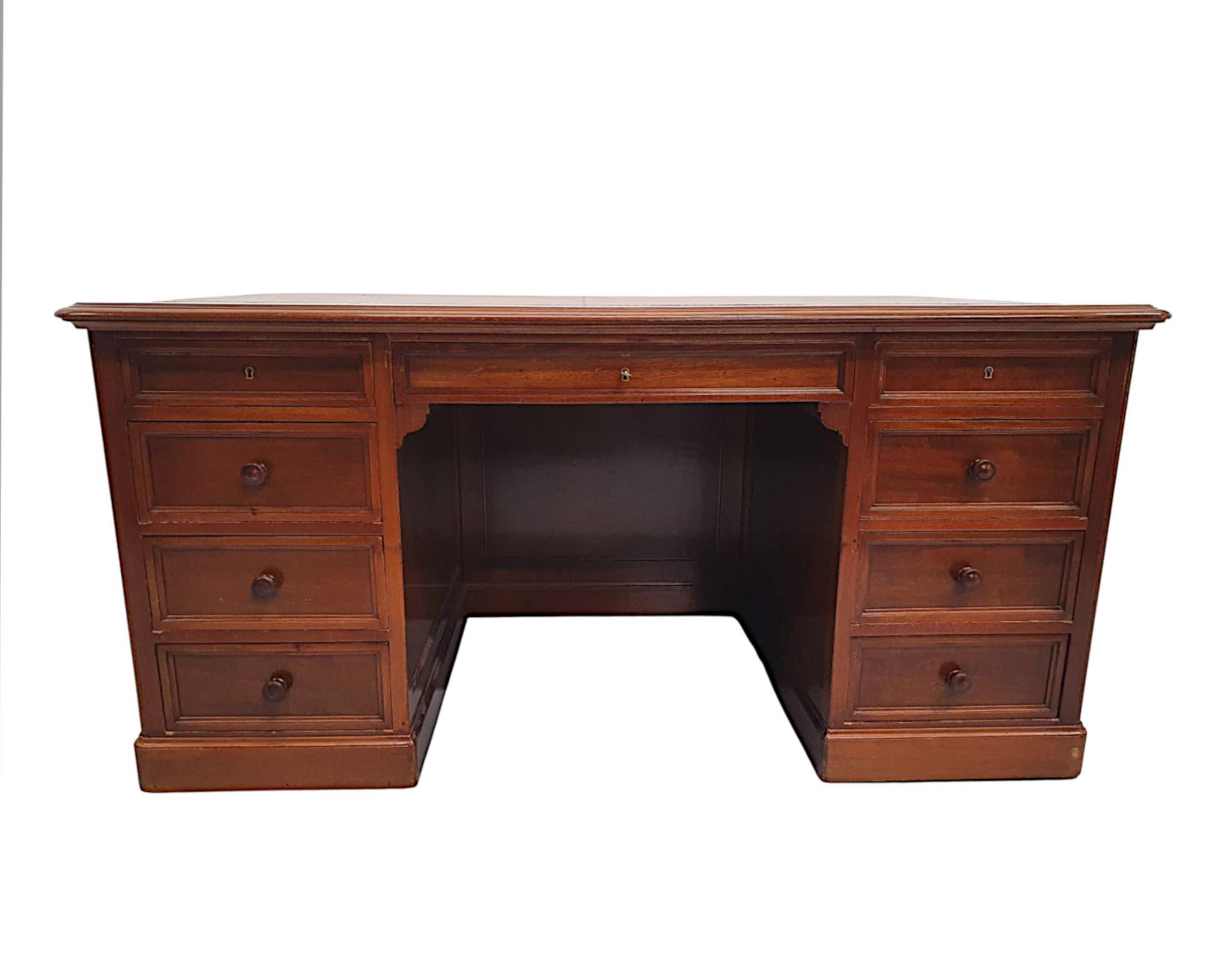 Un très beau bureau à piédestal à neuf tiroirs en acajou du XIXe siècle, finement sculpté à la main, d'une qualité fabuleuse et en excellent état, avec une patine et un grain riches.  Le plateau mouluré de forme rectangulaire est équipé d'une