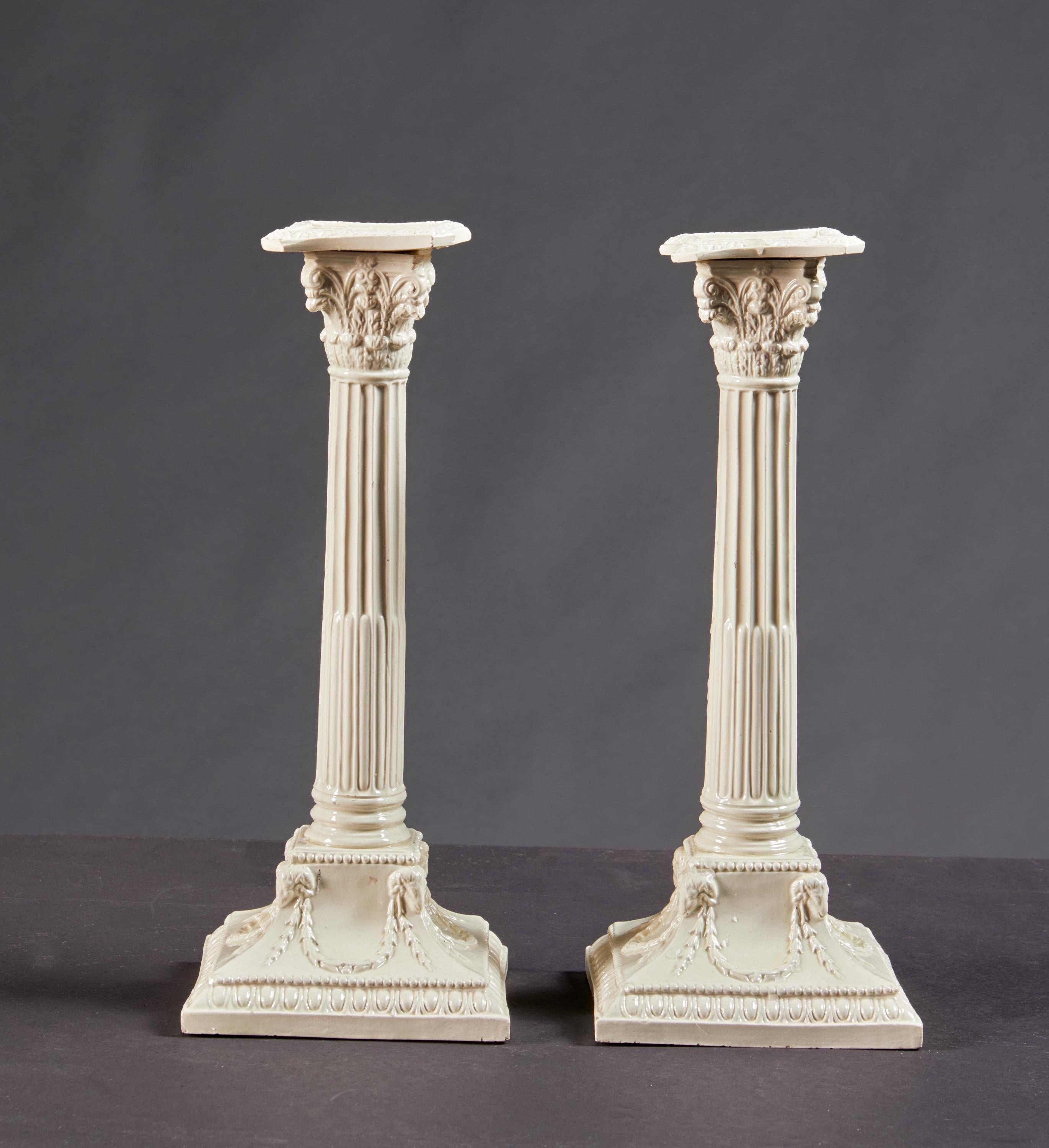 A pair of very fine creamware corinthian column, neo-classic period candlesticks with rams head garland decoration on square bases. English, circa 1770. Ex. Coll. Earle Vandekar of Knightsbridge, London.