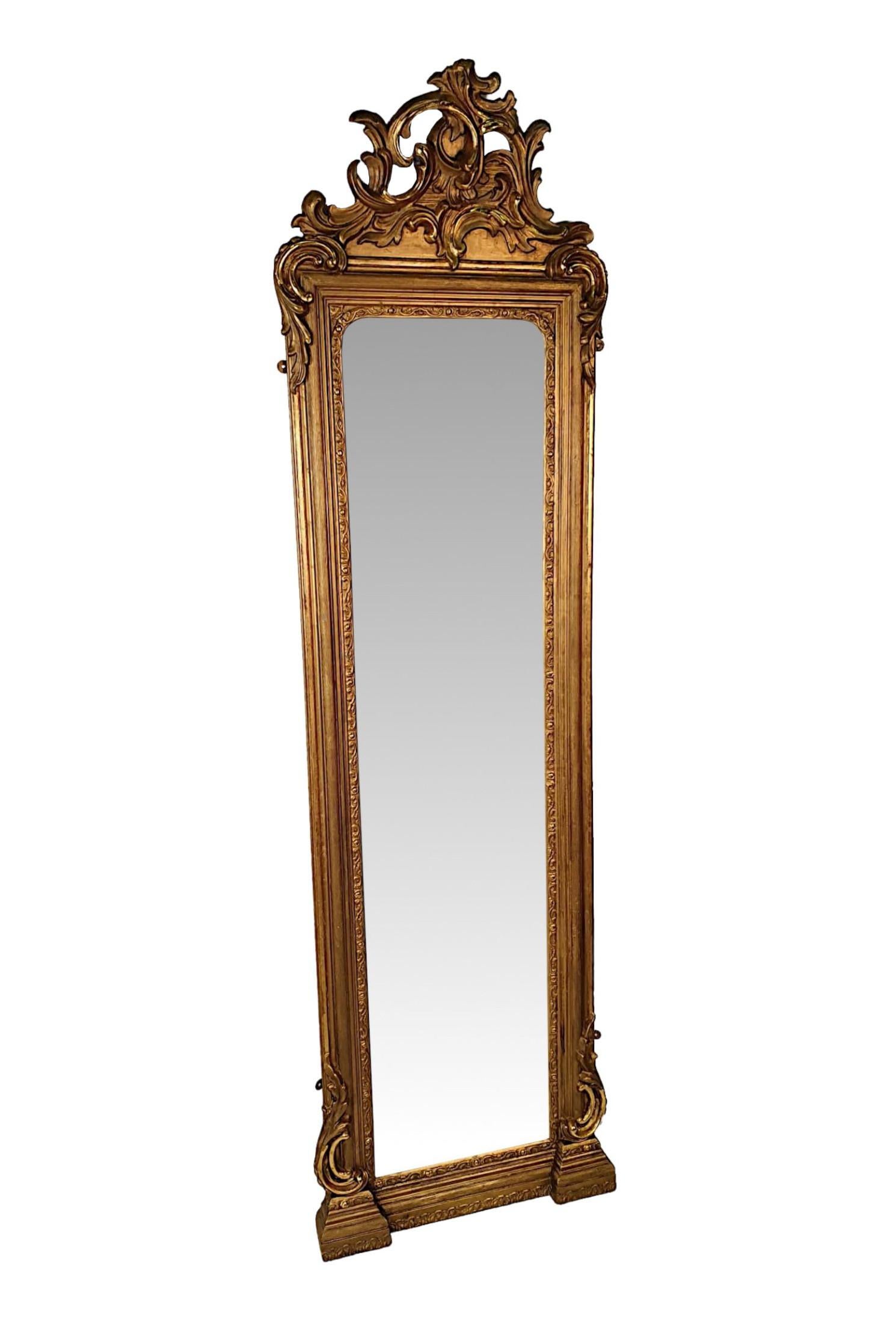 A very fine and rare 19th Century giltwood pier or dressing mirror of large and narrow proportions. The mirror glass plate of rectangular form set within a beautifully moulded giltwood frame with reeding, scroll and foliate motif detail, surmounted