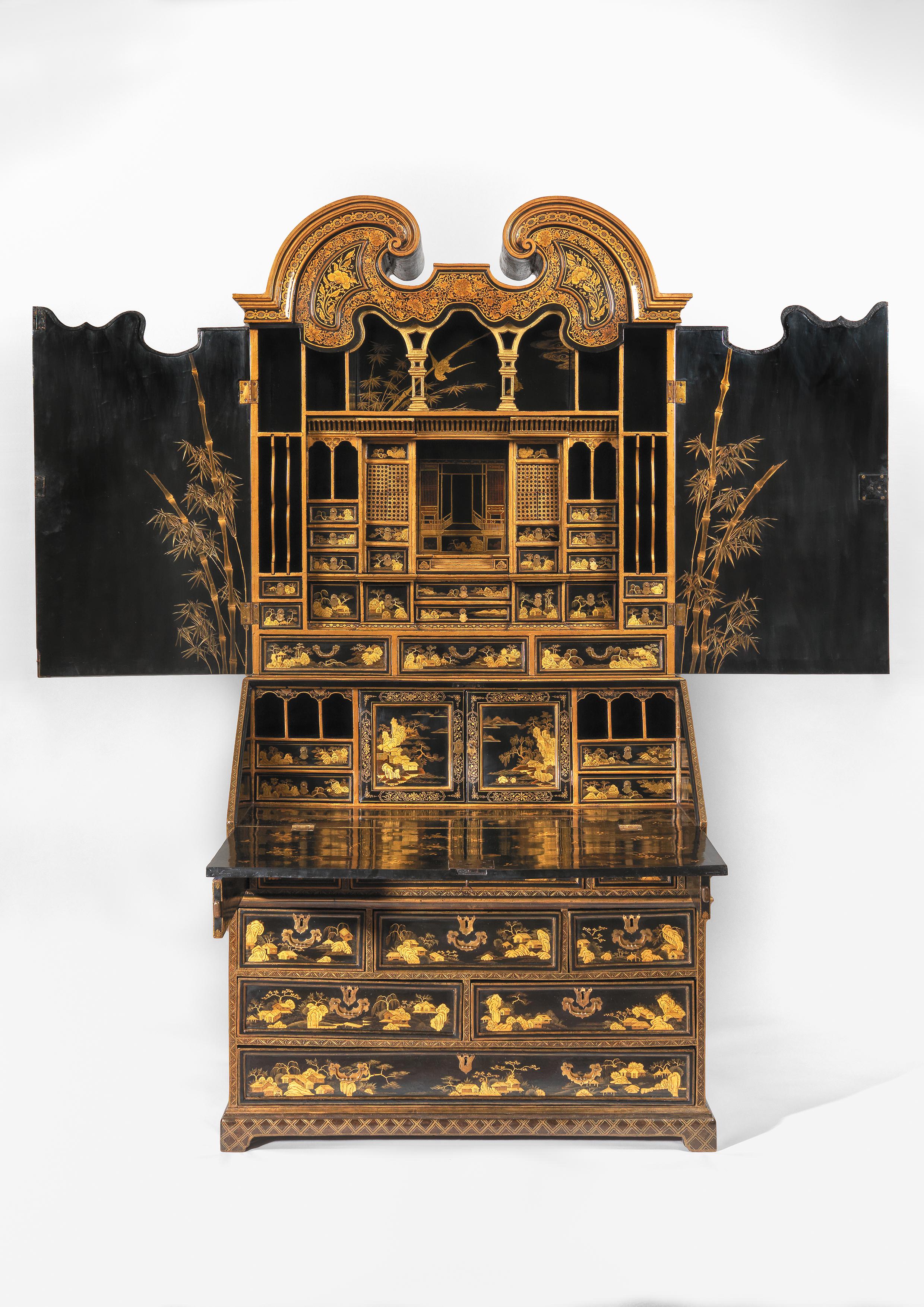 The upper section with a curved swan neck pediment decorated with floral decoration above a pair of doors opening to reveal an elaborate fitted interior. The base with a fall front opening to reveal more drawers with two internal doors with