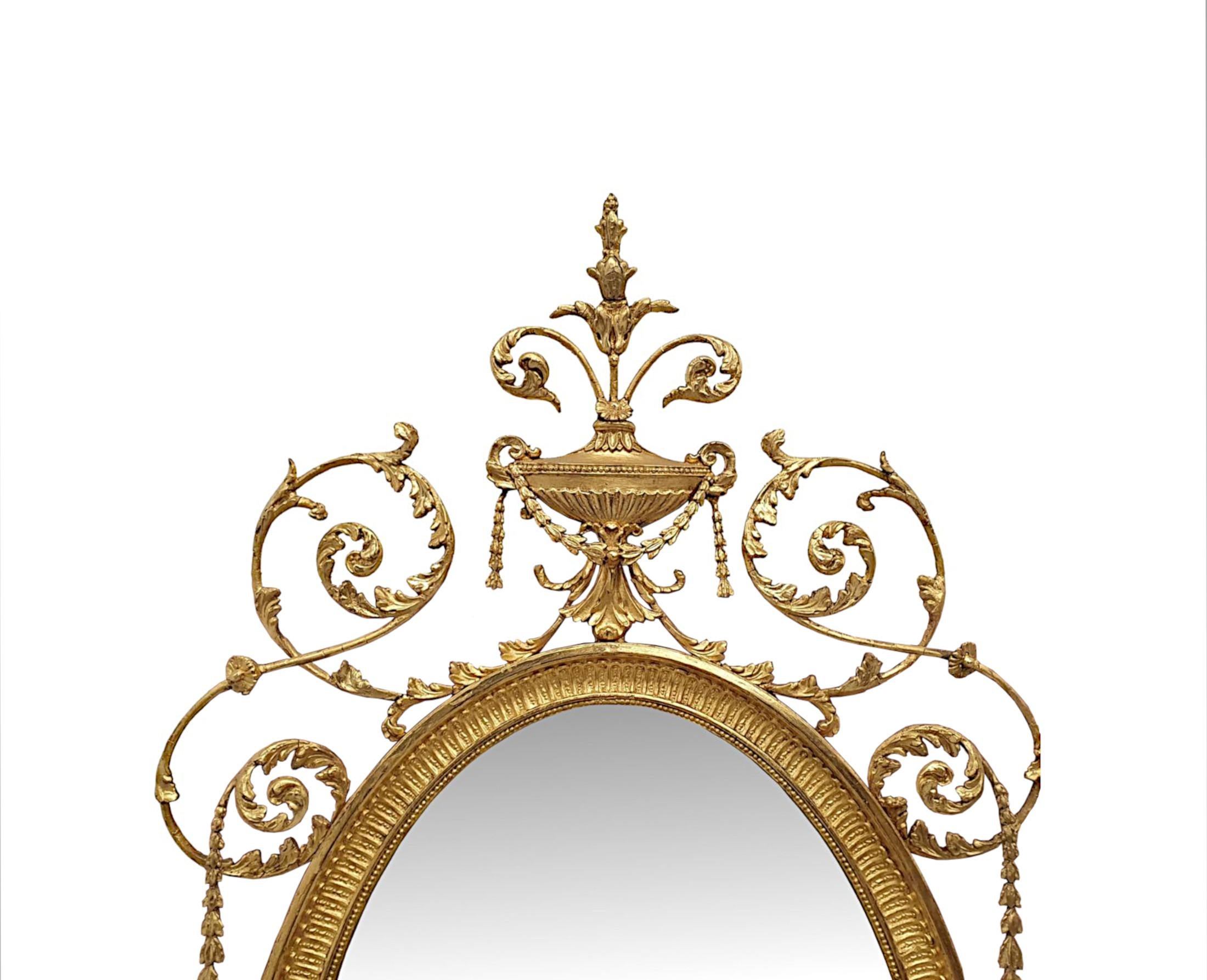 A very fine and rare late 19th Century giltwood overmantle or pier mirror in the manner of Adams, of impressive proportions and in lovely original condition.  The bevelled mirror glass plate of oval form is set within stunningly hand carved, moulded