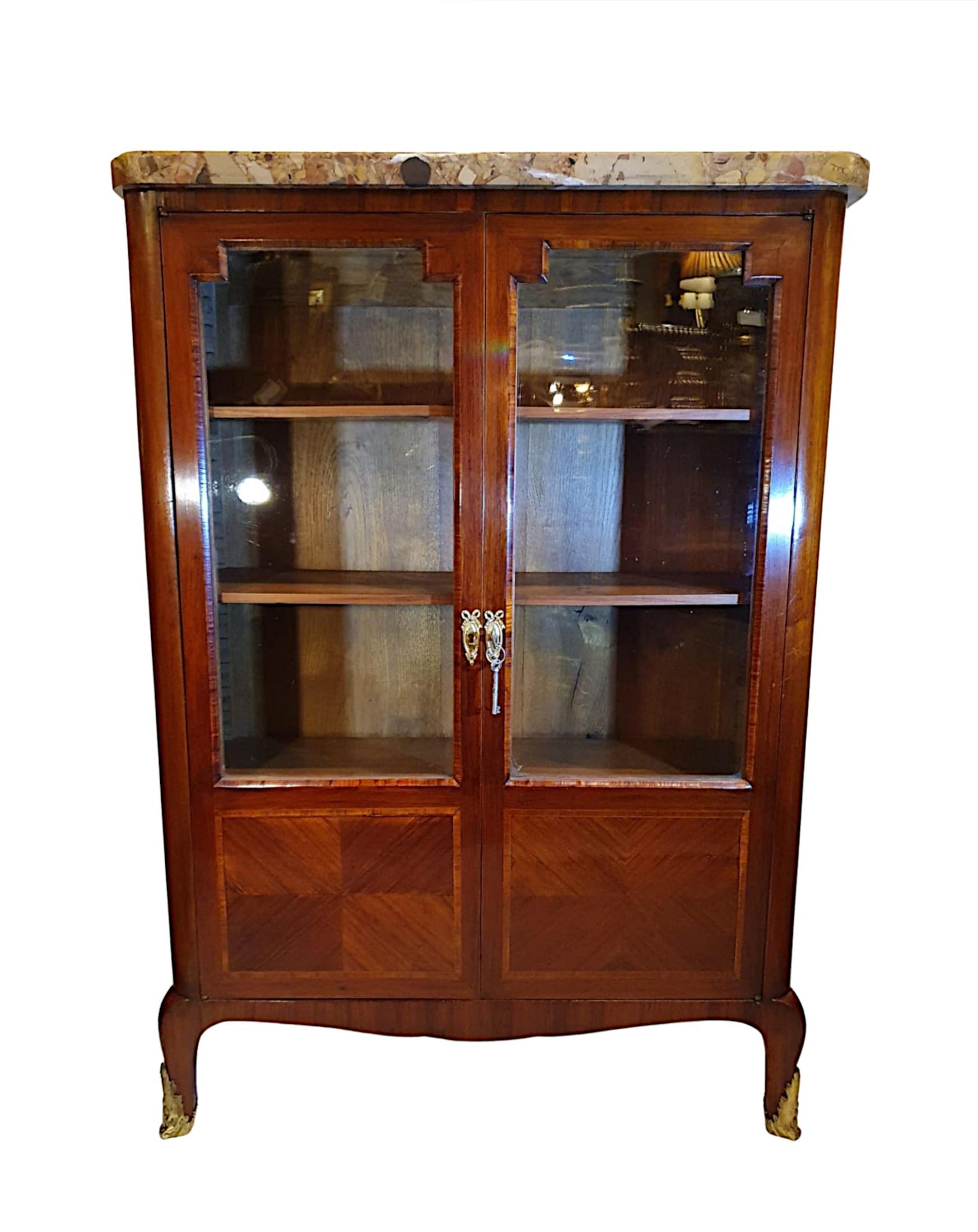 A very fine and rare pair of 19th century French marble top crossbanded kingwood and fruitwood bookcases. The moulded breche d’alep marble top of rectangular form raised over two panelled glazed doors with decorative brass escutcheons opening to a