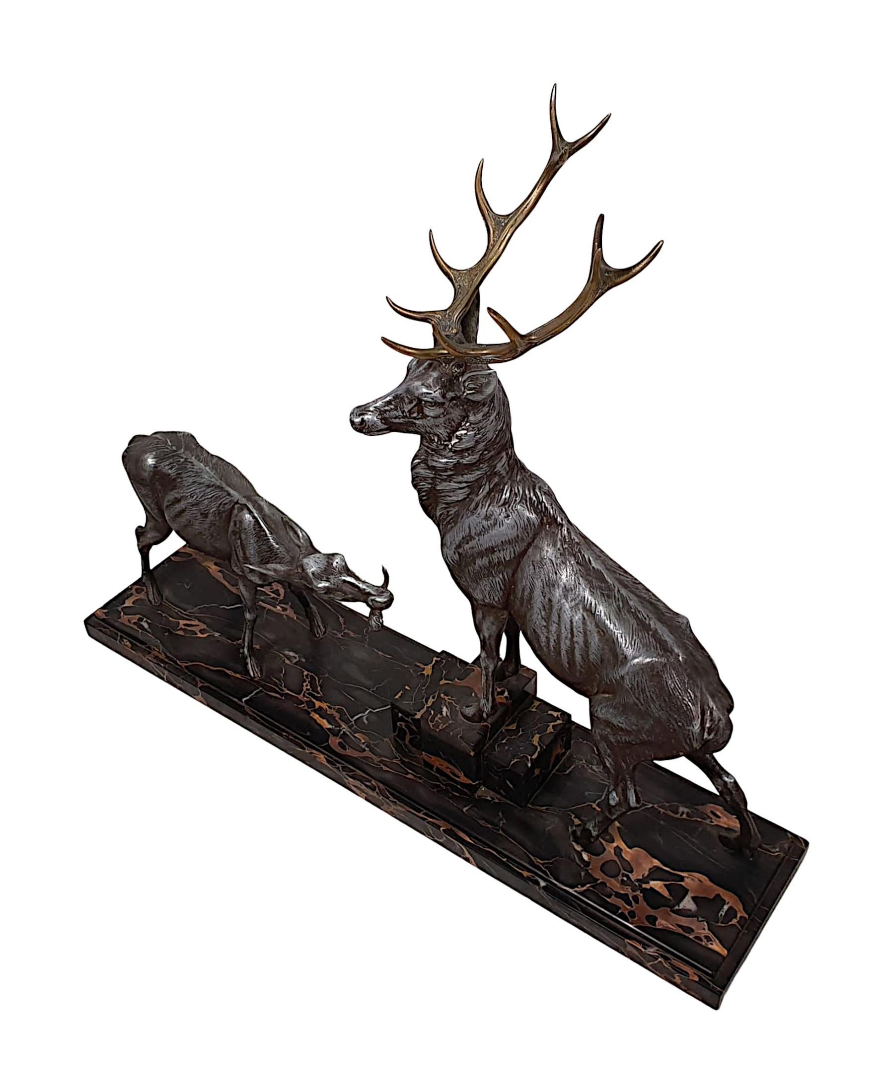 Très belle sculpture animalière Art Déco en métal et laiton représentant un cerf et une biche par Louis Albert Carvin, montée sur une superbe base moulée en marbre italien Margraf noir et orange de forme rectangulaire, signée L. Carvin.