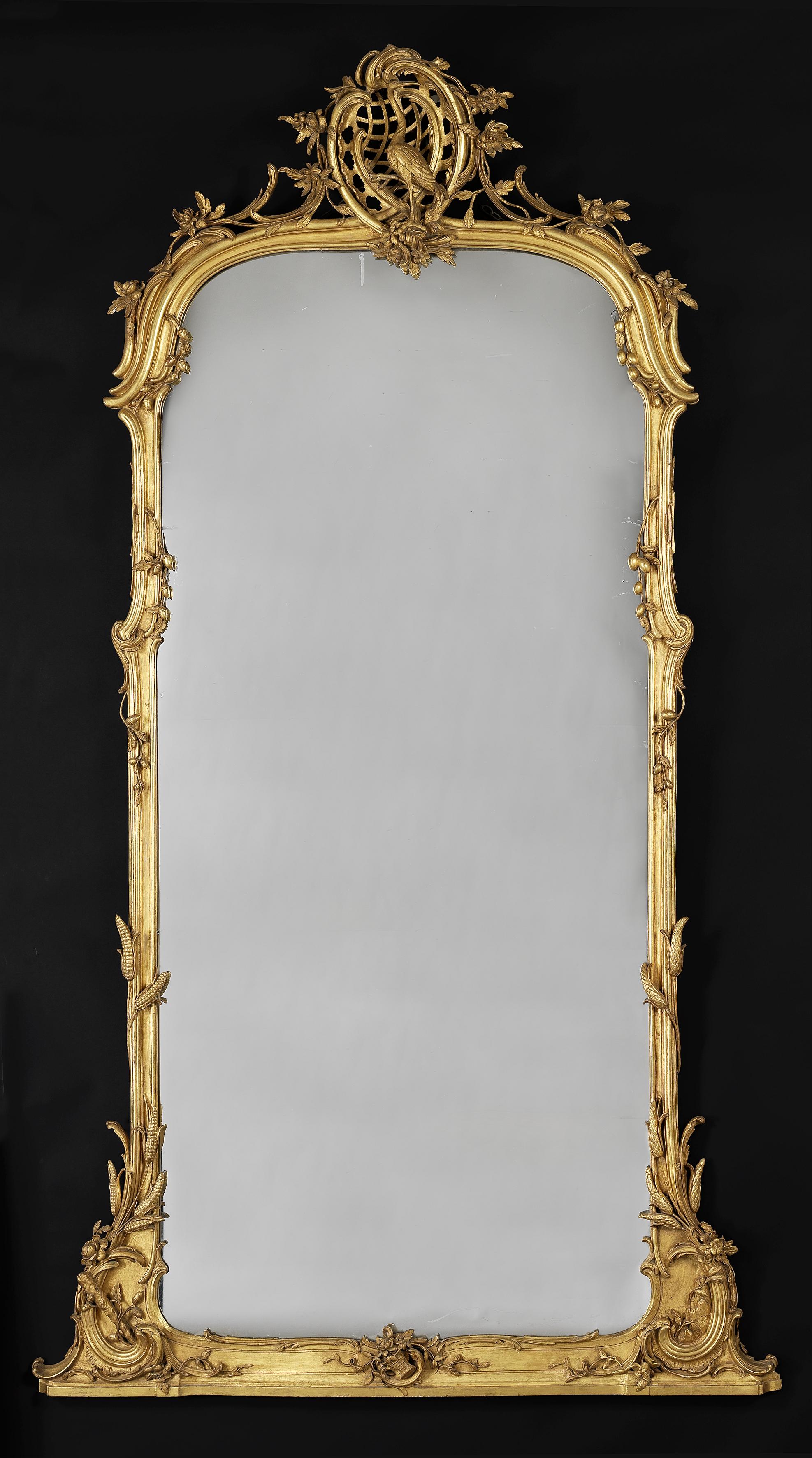 Un très beau miroir en bois doré sculpté.

Allemand, vers 1860.

L'encadrement mouluré est sculpté de gerbes de blé et de formes feuillues entrelacées, surmonté d'un cartouche rocaille ajouré centré par la figure d'une Grue.