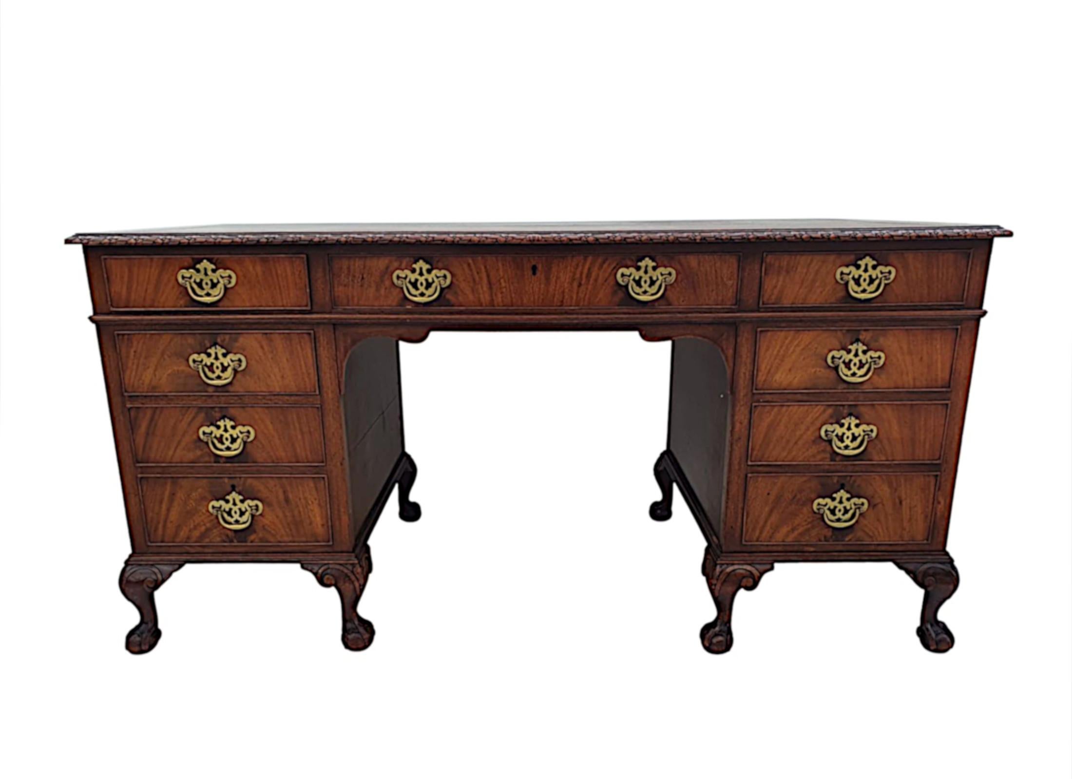 A very fine early 20th Century nine drawer desk, labelled 'Waring and Gillow'. The moulded top of rectangular form fitted with brown embossed tooled leather writing skiver surface and with a beautifully carved moulded edge with flowerhead motif