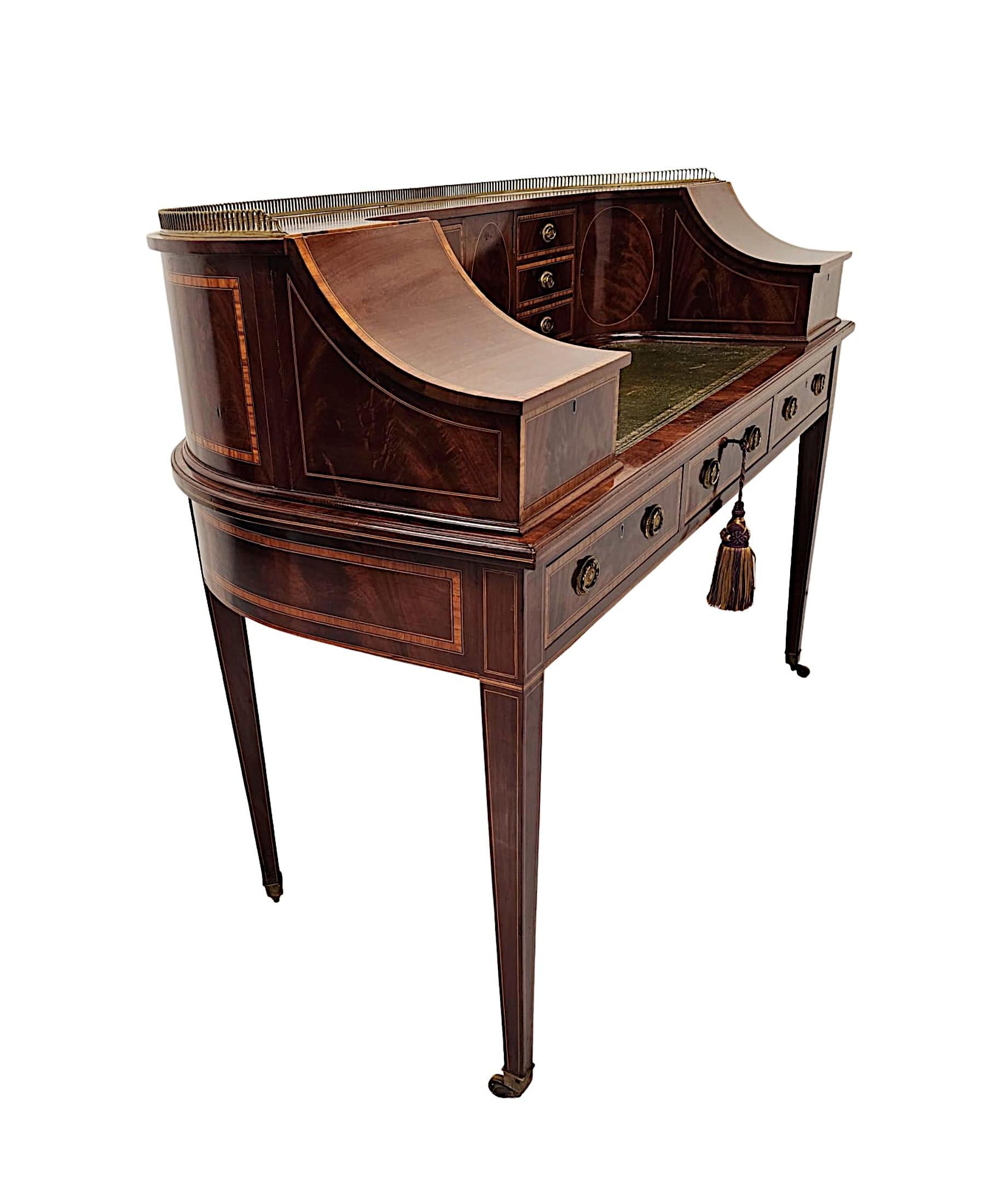 A very fine Edwardian richly patinated and beautifully figured mahogany Carlton House style desk of exceptional quality, stunningly carved with delicate line inlay and fabulous crossbanded detail throughout.  The moulded and curved upper section