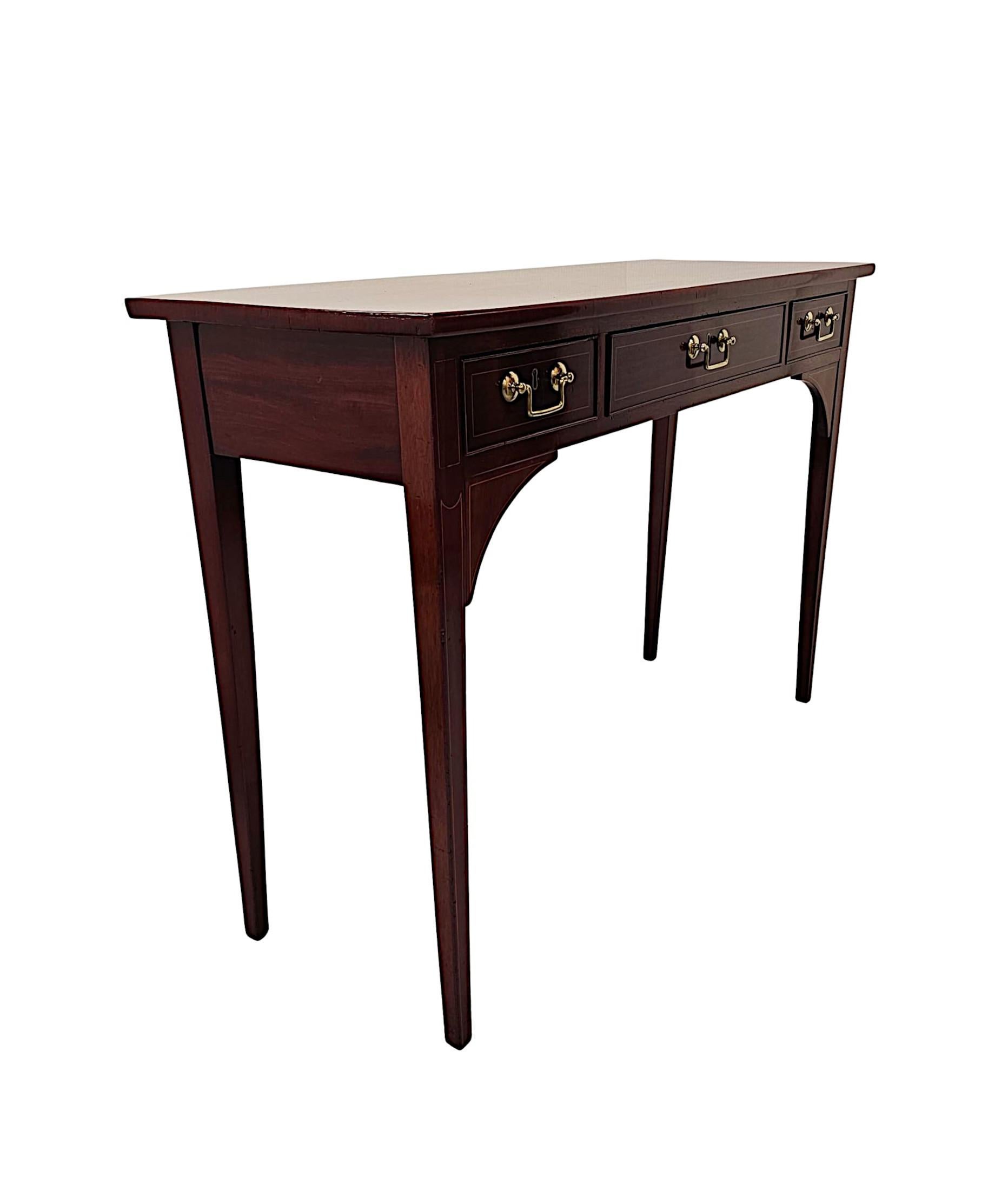 A very fine Edwardian mahogany console table of neat proportions, exceptional quality and beautifully carved with rich patination, grain and with delicate line inlaid panel detail throughout. The finely figured moulded top of rectangular form is