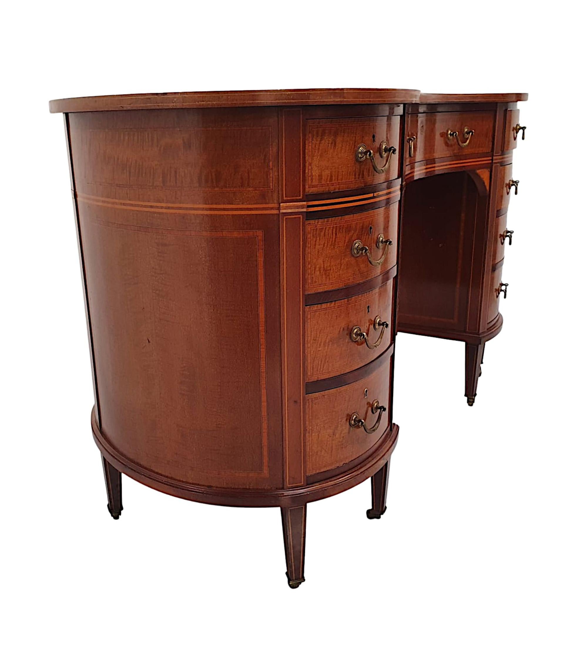 A very fine Edwardian mahogany leather top nine drawer kidney shaped desk, of stunning quality, finely carved, line inlaid and crossbanded throughout.  The moulded desk top is fitted with a gorgeous green tooled leather writing skiver surface above