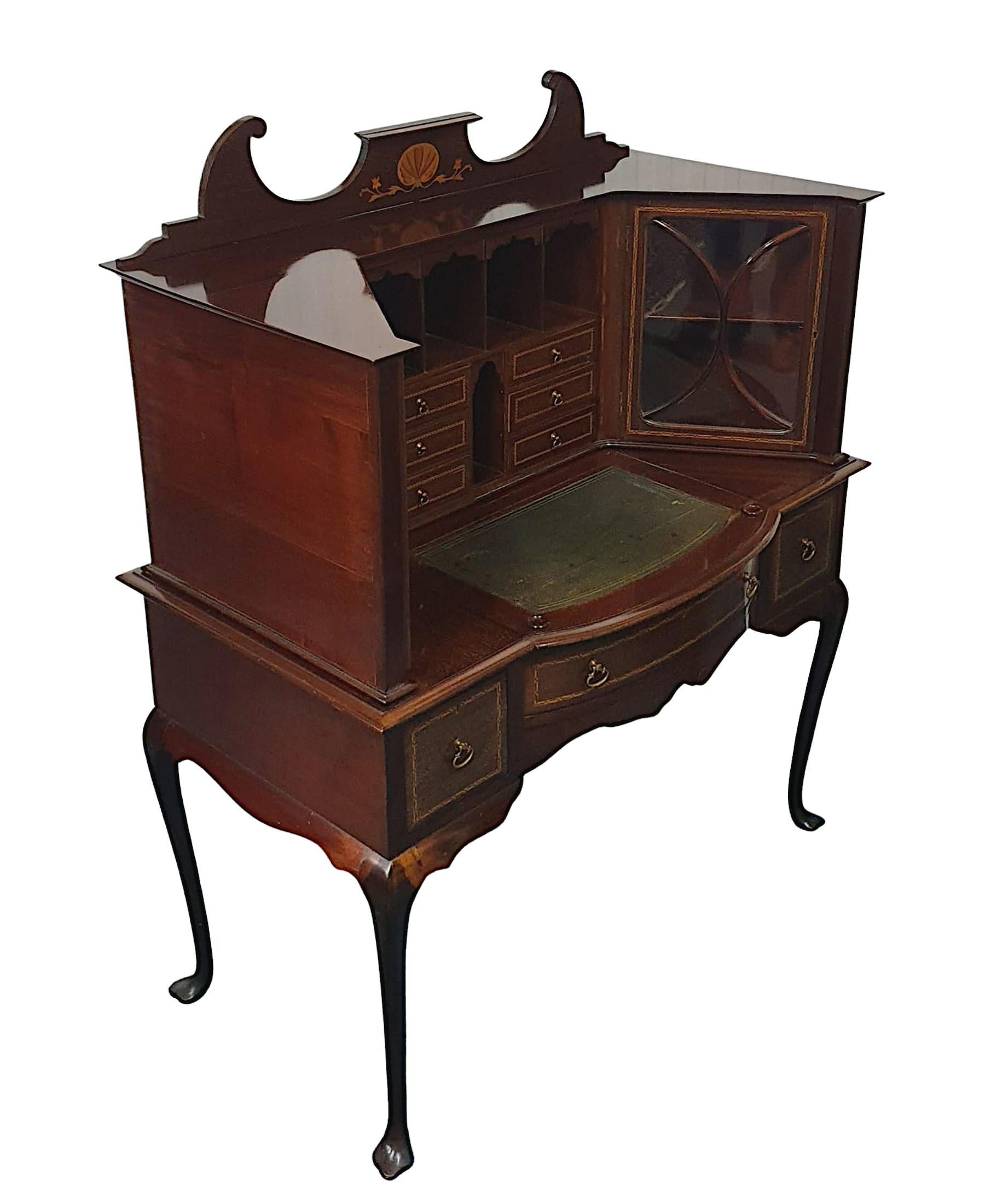 A very fine Edwardian mahogany ladies desk or vanity cabinet, the broken swan neck pediment inlaid with shell and scrolling foliate motif raised over a pair of astragal glazed cabinet doors with shelved interior flanking fitted letter racks and six
