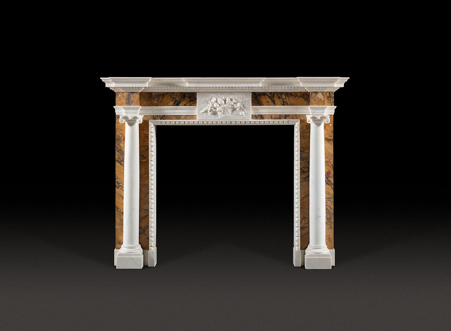 Ein sehr feiner Kamin aus dem achtzehnten Jahrhundert, die Breakfront Regal über einem Siena Marmor Fries, durch eine statuarische Marmortafel mit reichlich Obst geschnitzt zentriert. Die vorspringenden Eckblöcke aus Siena-Marmor sitzen über sehr