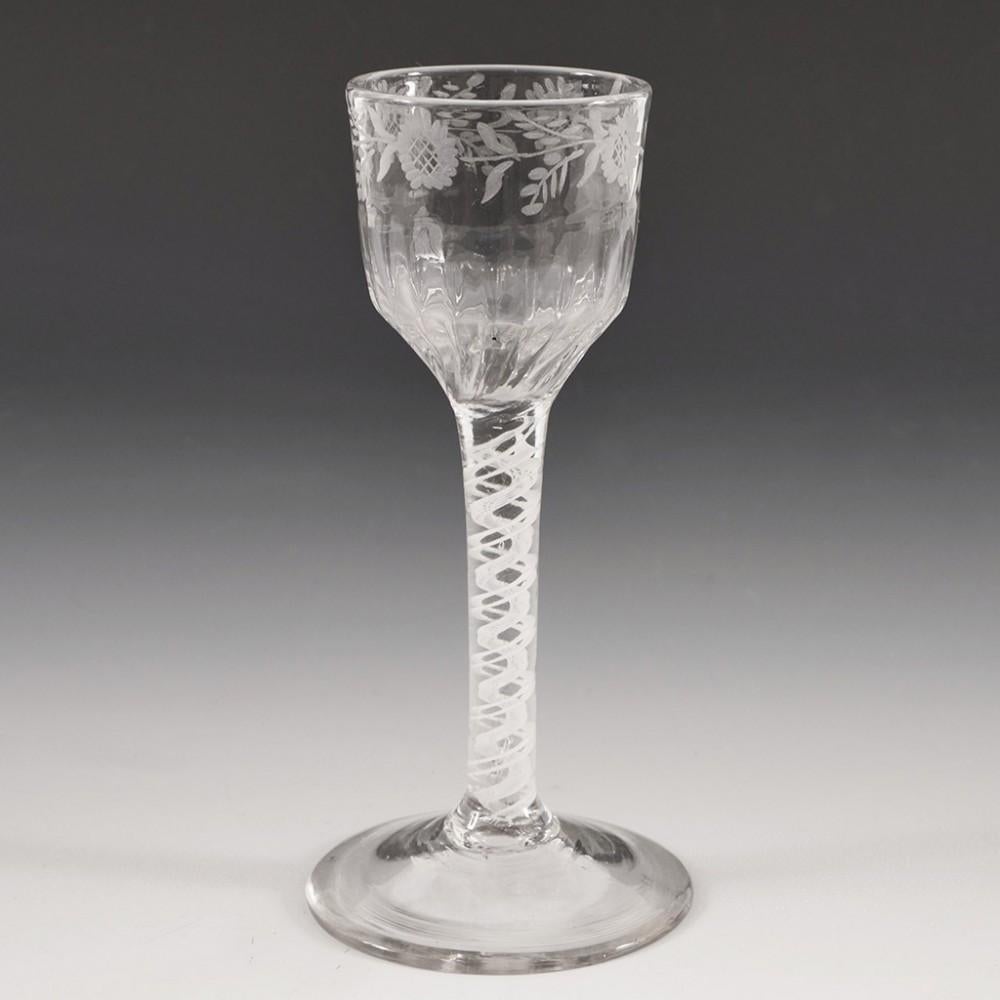 Heading : A Very Fine Engraved Single Series Opaque Twist Wine Glass c1760
Period : George II- George III
Origin : England
Colour : Clear, light grey tone
Bowl : Petal moulded ogee. Engraved band of sunflowers and leaves
Stem : A pair of spiral
