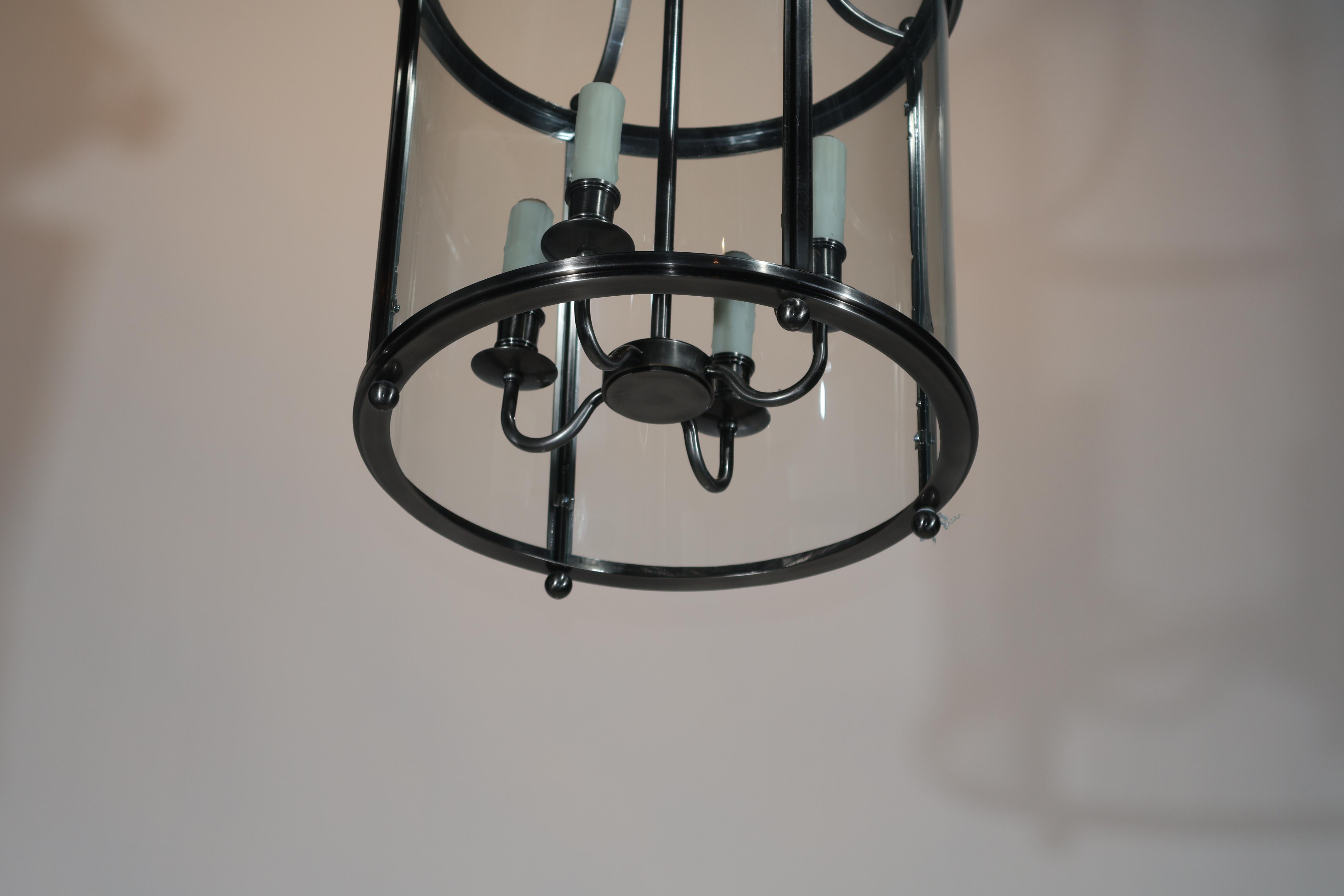 Très belle lanterne cylindrique moderne à quatre lumières. Panneaux de verre incurvés d'origine. Finition en acier brossé. 20e siècle.
Dimensions : Hauteur 26 1/2
