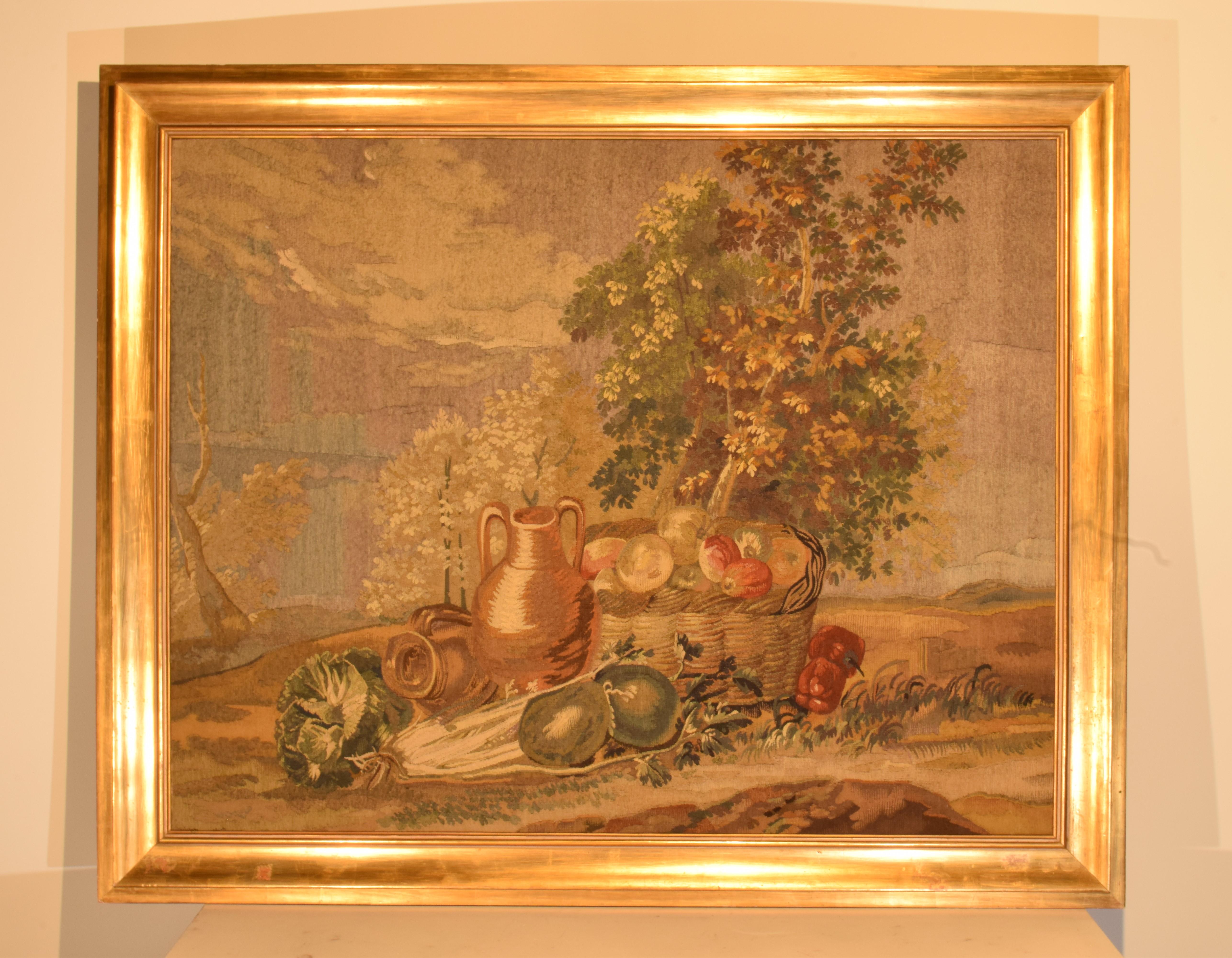 A Very Fine Tapestry depicting a tree in the background and a basket with fruits & pitcher in the foreground. Mounted in wooden gilt painted frame. 
Dimensions: Height 43 3/4