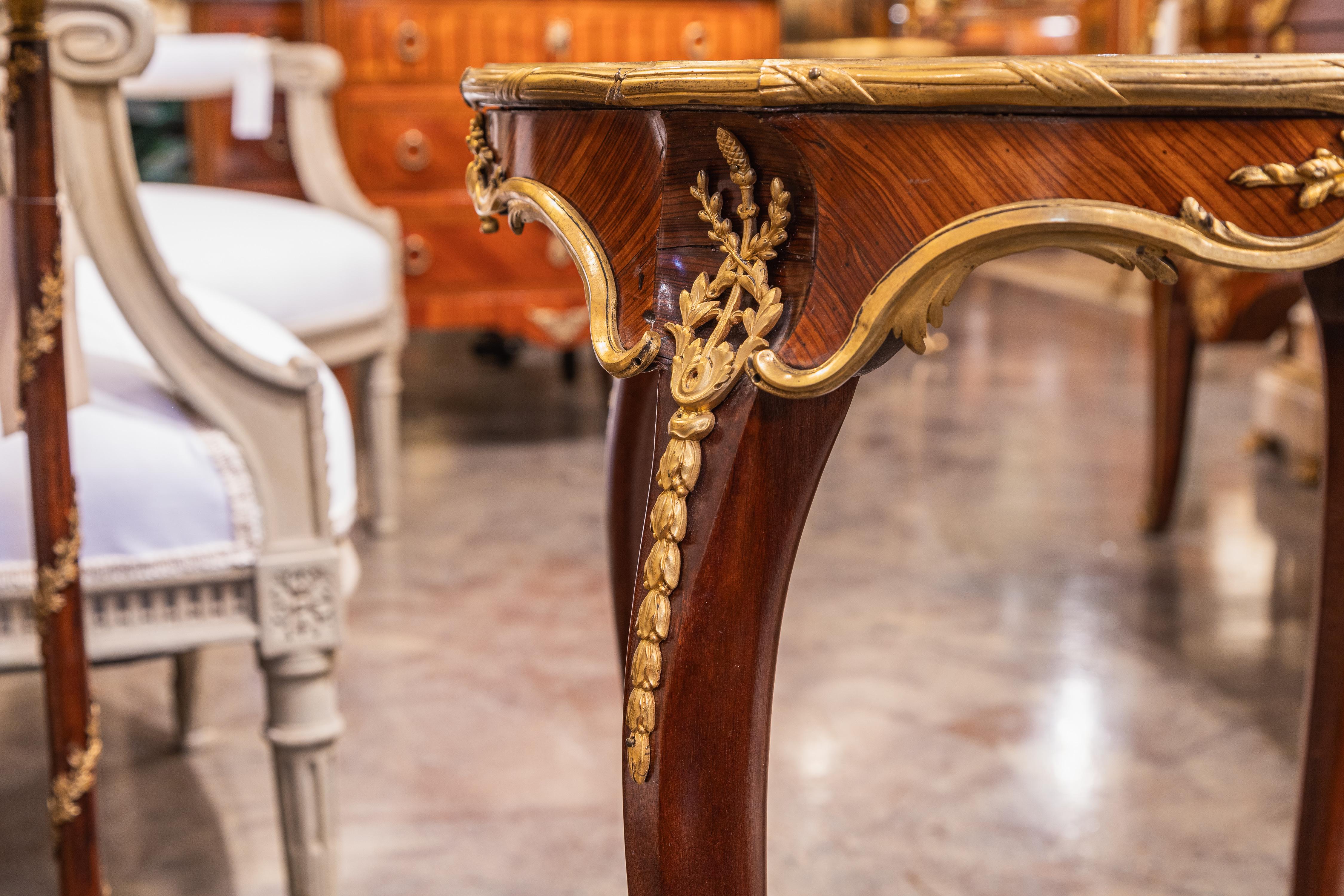 Table d'appoint en acajou Louis XV du XIXe siècle, avec des montures en bronze doré de grande qualité. Le plateau est orné d'une belle marqueterie. 