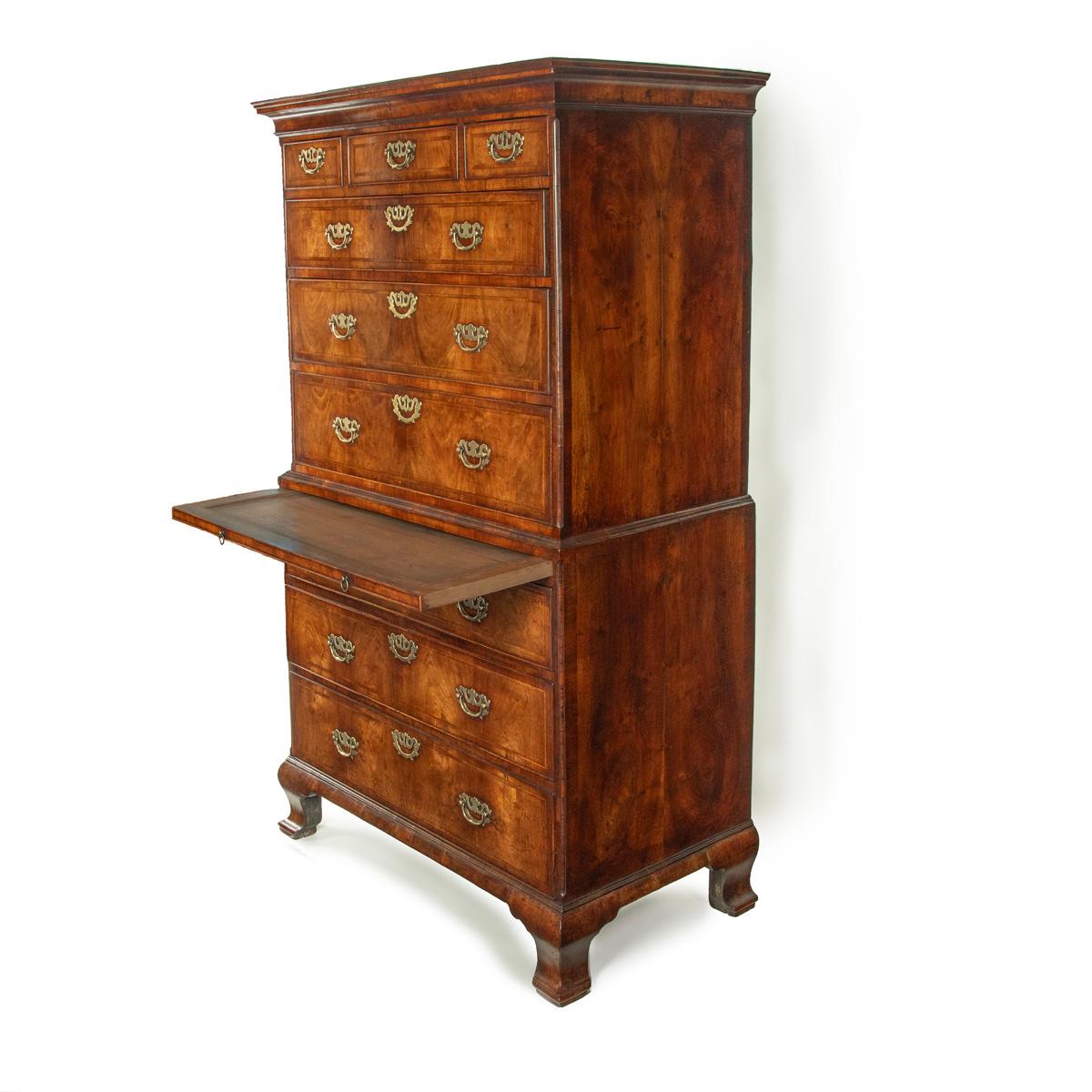 A very fine George I walnut tallboy, of typical rectangular form with a wide base containing three graduated long drawers and a narrower upper section with three further long drawers and three short drawers below a shaped cornice, all raised on a