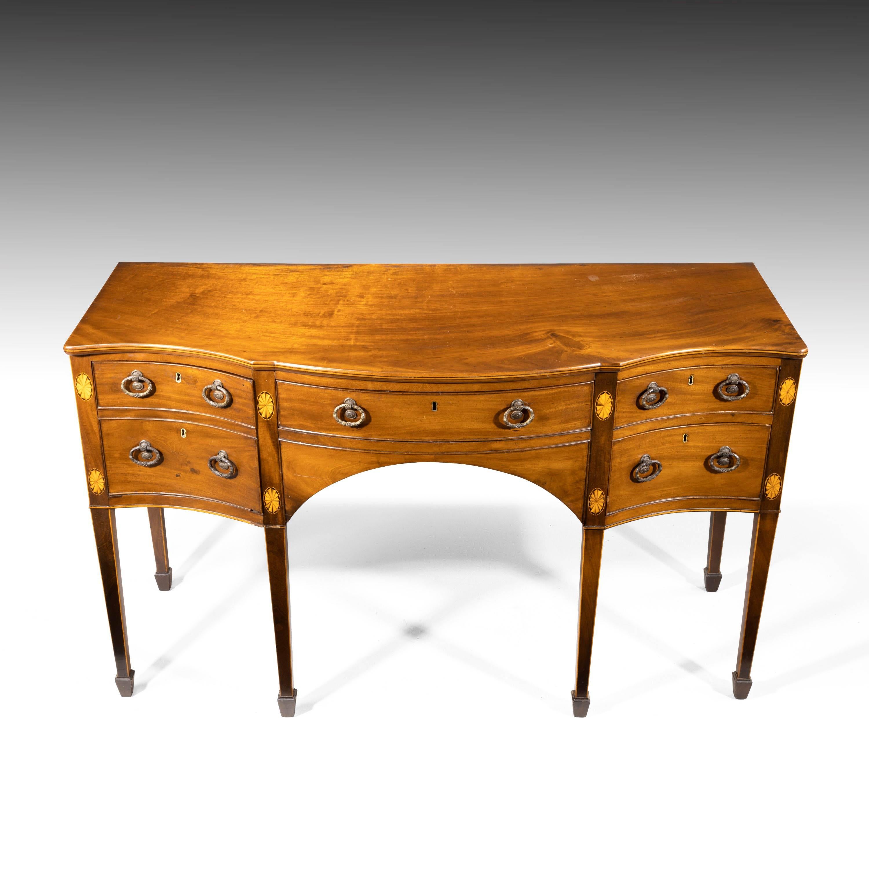 Ascribed to Gillows of Lancaster, a fine George III period serpentine mahogany sideboard. Of excellent color and patina. The uprights with sunburst inlays to the top and shoulders. Very fine original two-section gilt bronze handles, absolutely