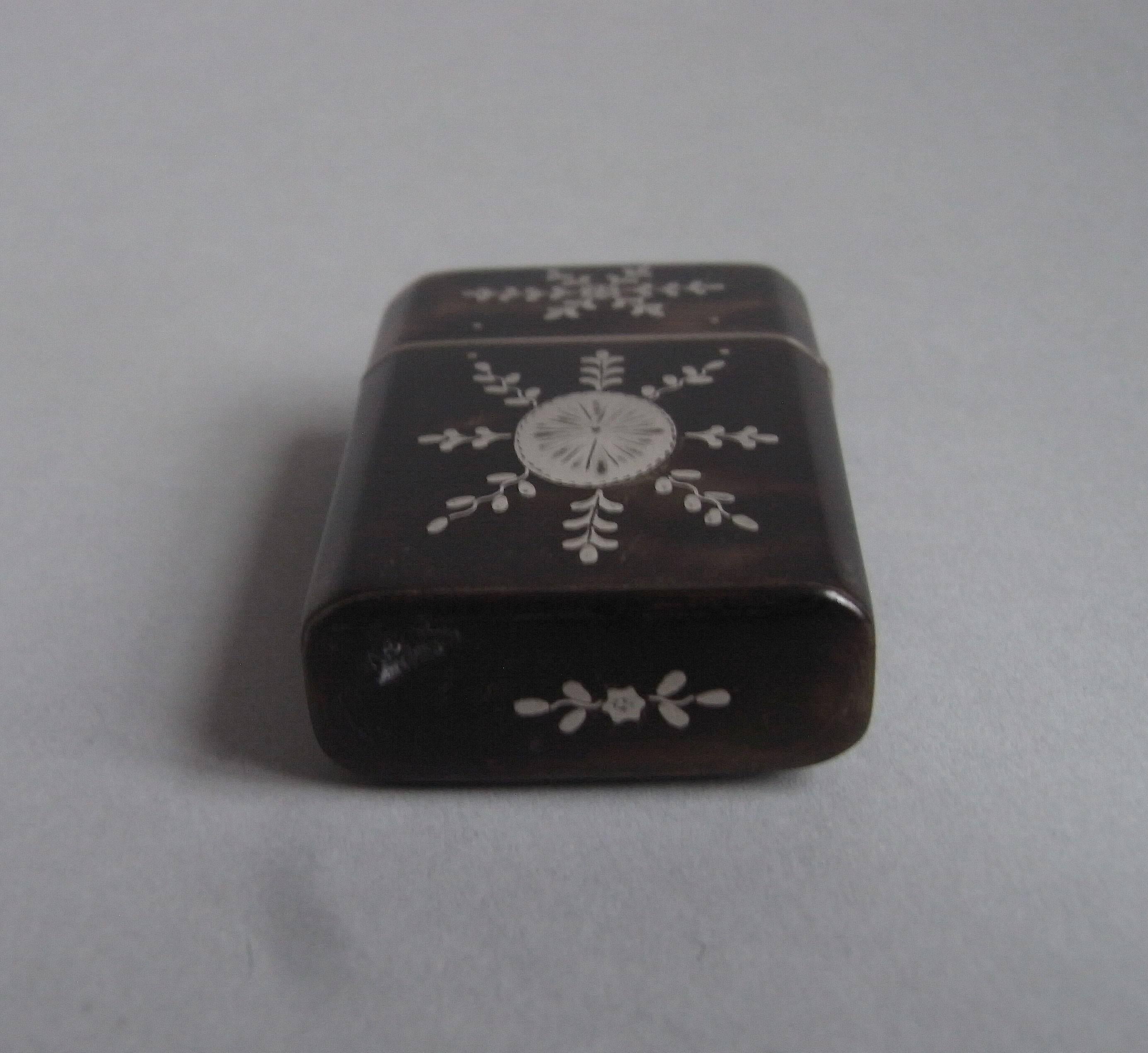 The Etui is of a slightly tapering rectangular form, with cut corners. The main body is decorated, on both sides, with stylized snow flake designs, around a central oval classical medallion. The hinged cover opens up to reveal the two original