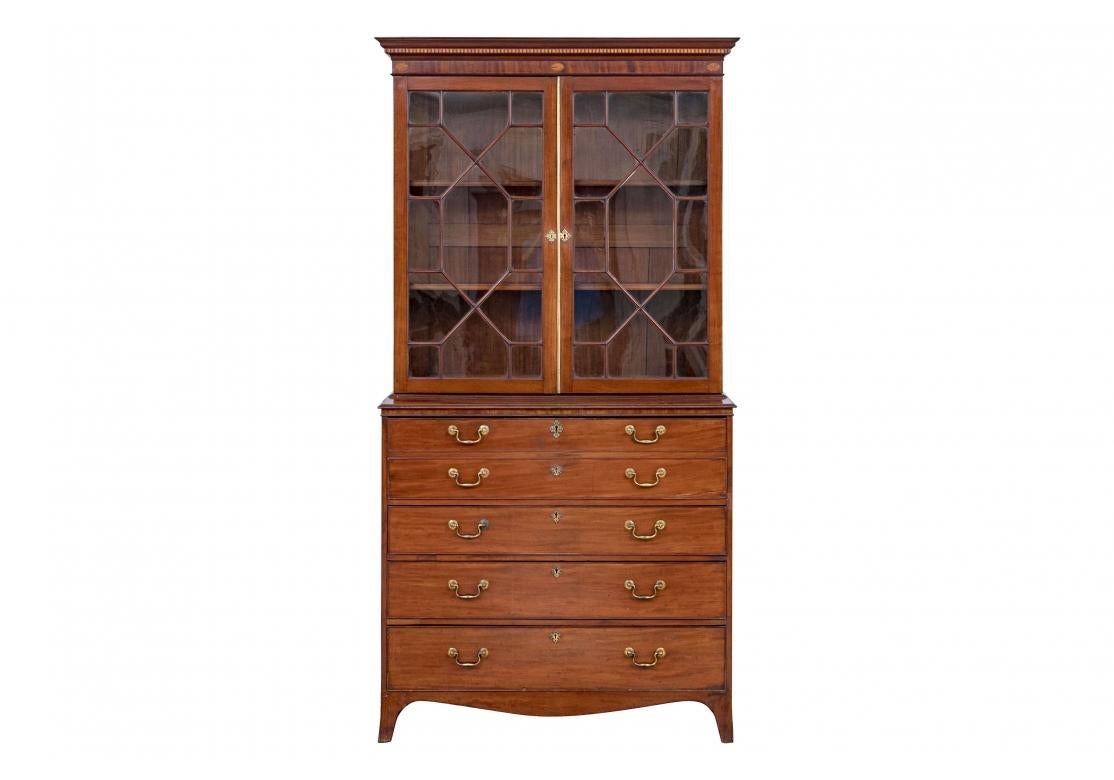 A 19th Century English Secretary with fine craftsmanship throughout including dove-tail drawer construction, original brass pulls and escutcheons, banded interior drawers, inlaid wood decoration and handsome lattice work glass doors opening to two
