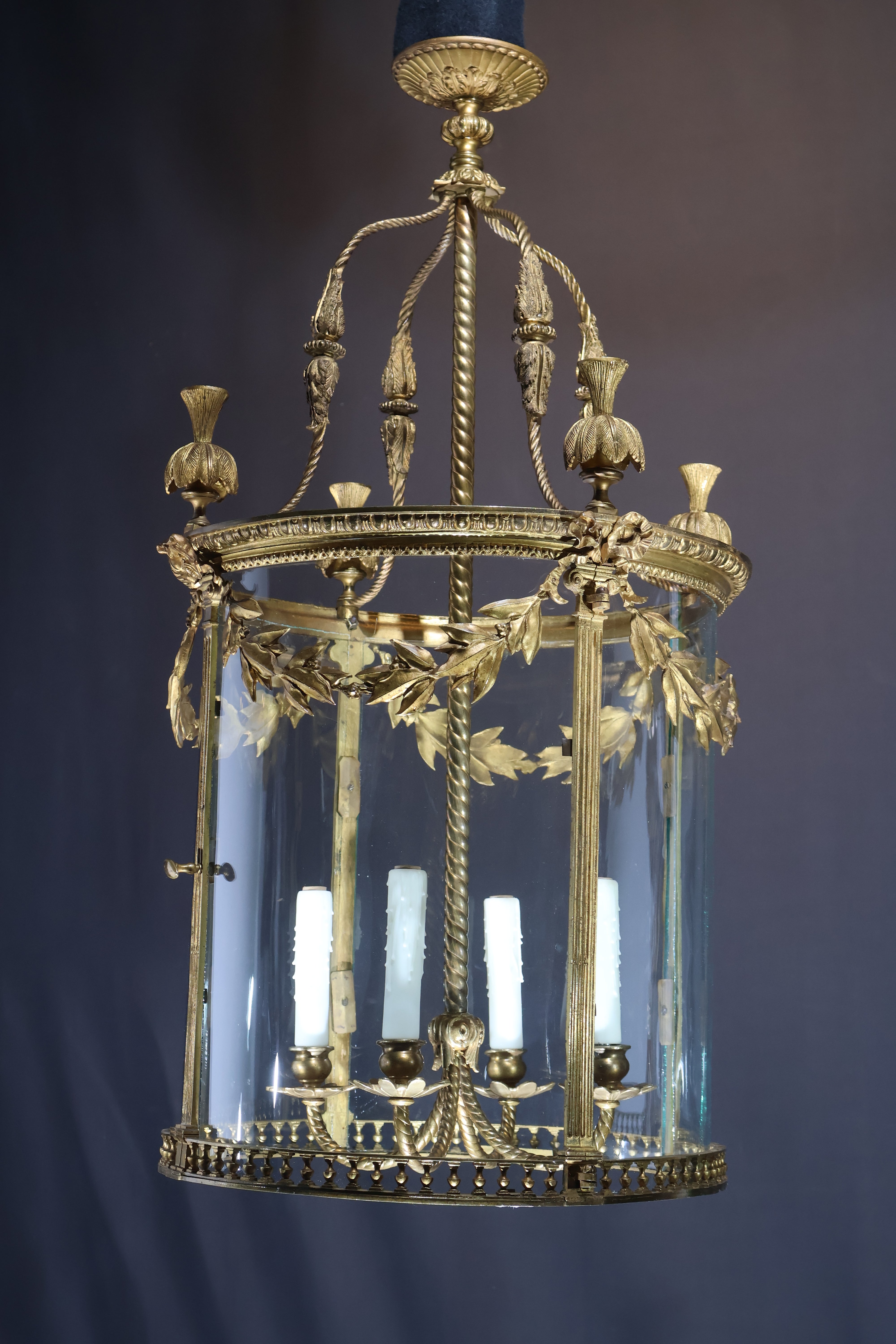 Très belle et élégante lanterne en bronze doré de style Louis XVI, ornée de guirlandes de laurier, de panneaux de verre incurvés et d'une galerie inférieure percée. 4 lumières. France, vers 1910. 
Dimensions : Hauteur 38 1/2