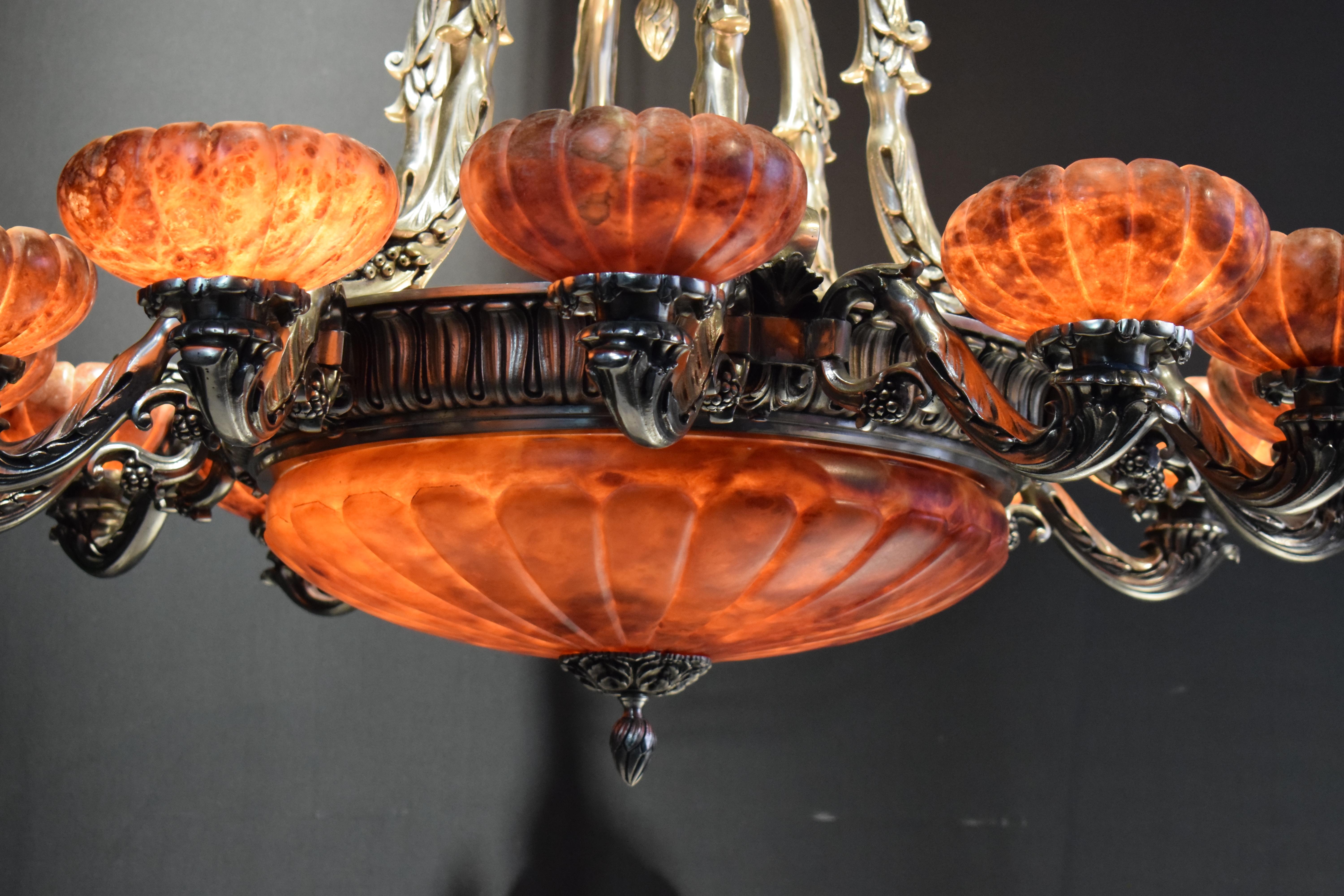 A Fine Gilt bronze chandelier in the Louis XVI taste, having guilloche patterned supports with floral garlands, a carved alabaster bowl issuing ten curving arms with scalloped alabaster shades, and five additional internal lights, apparently