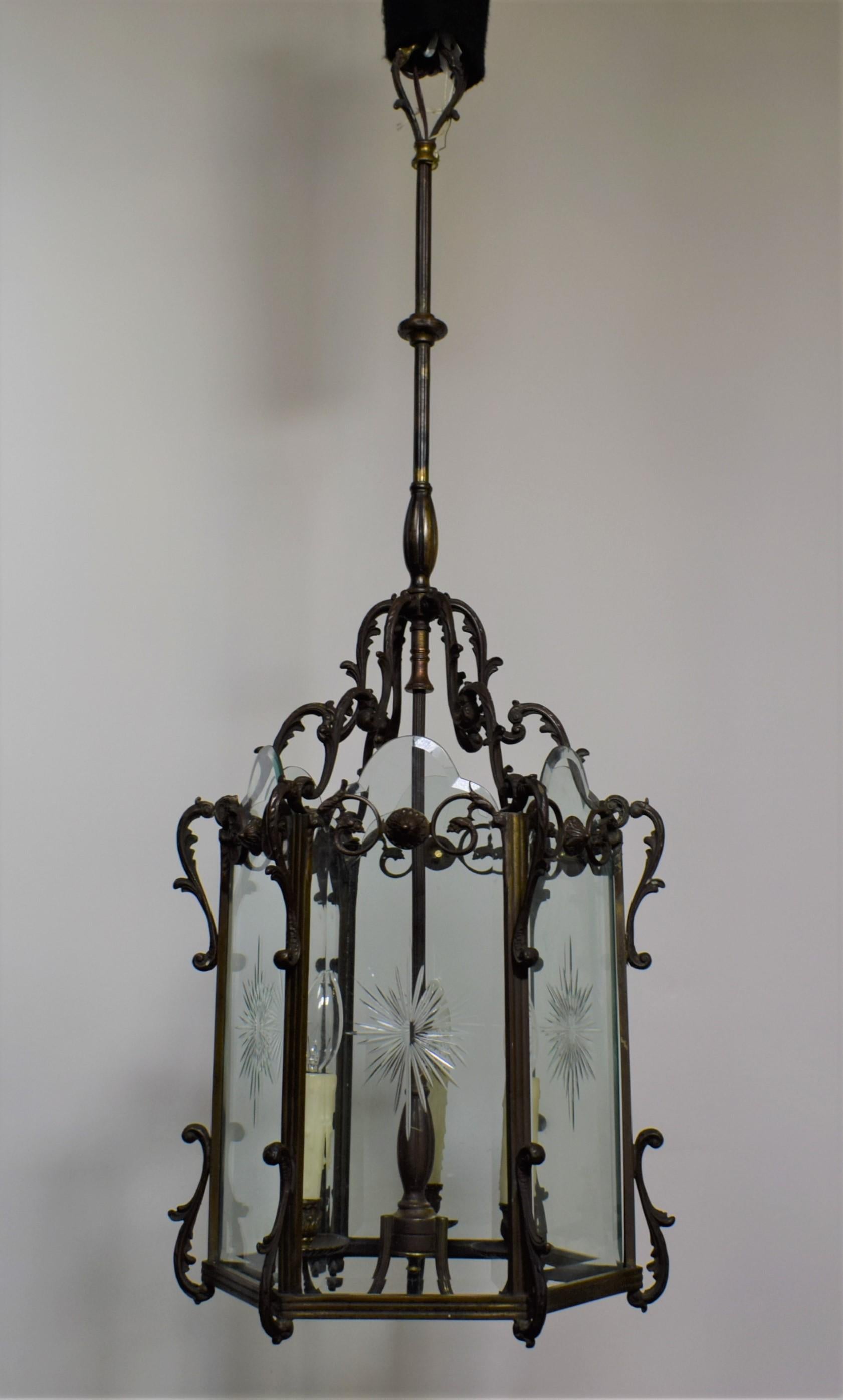 A very fine hexagonal bronze lantern with beveled and hand cut sunburst decorated panels. 3 lights.
France, circa 1920.
Dimensions: Overall height 40