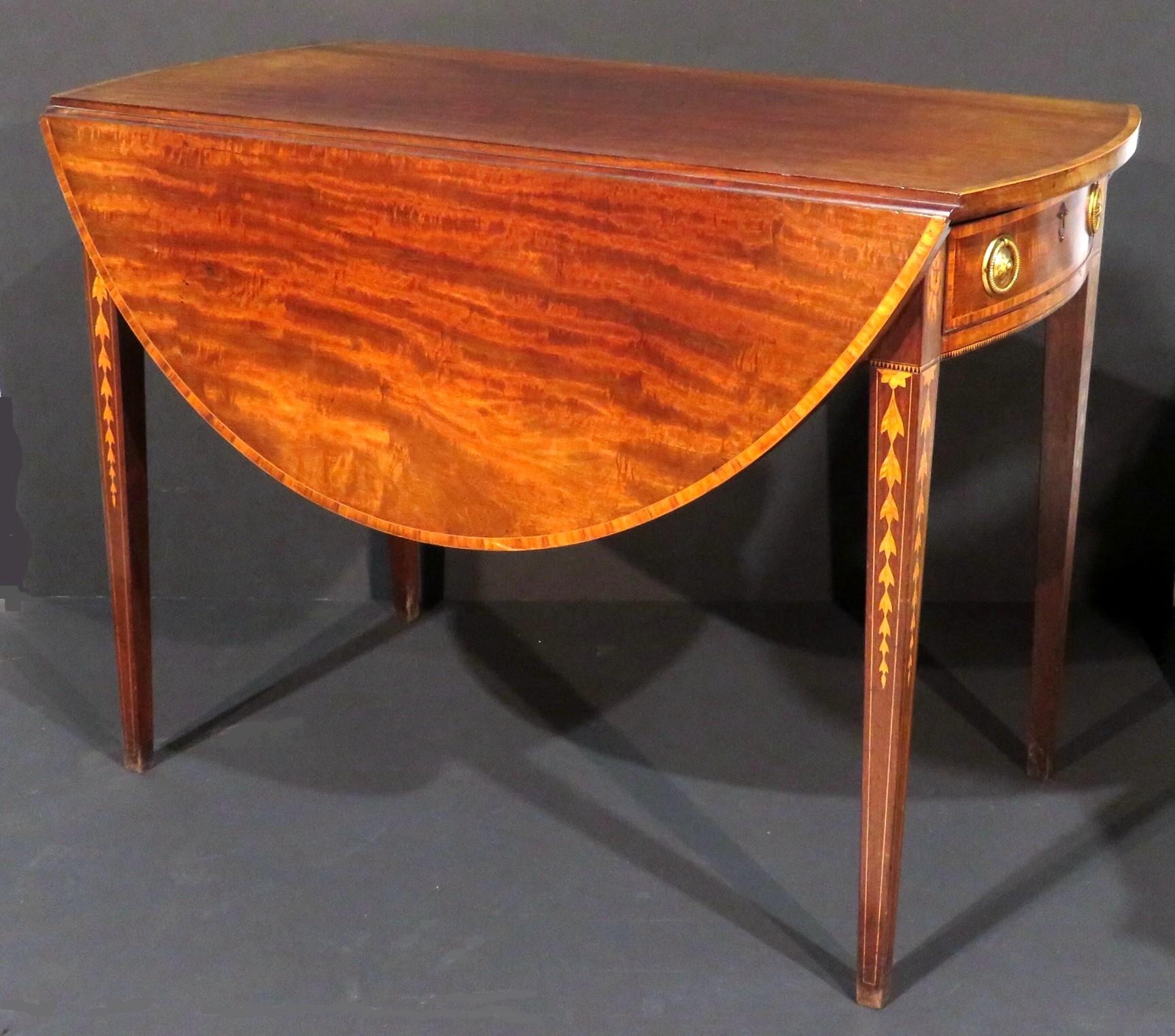 A very fine George III Pembroke table in highly figured mahogany, the solid mahogany top inlaid with a satinwood crossbanded edge sided by two similarly addressed demi-lune drop leaves braced from the underside by twin gateleg supports. The frieze