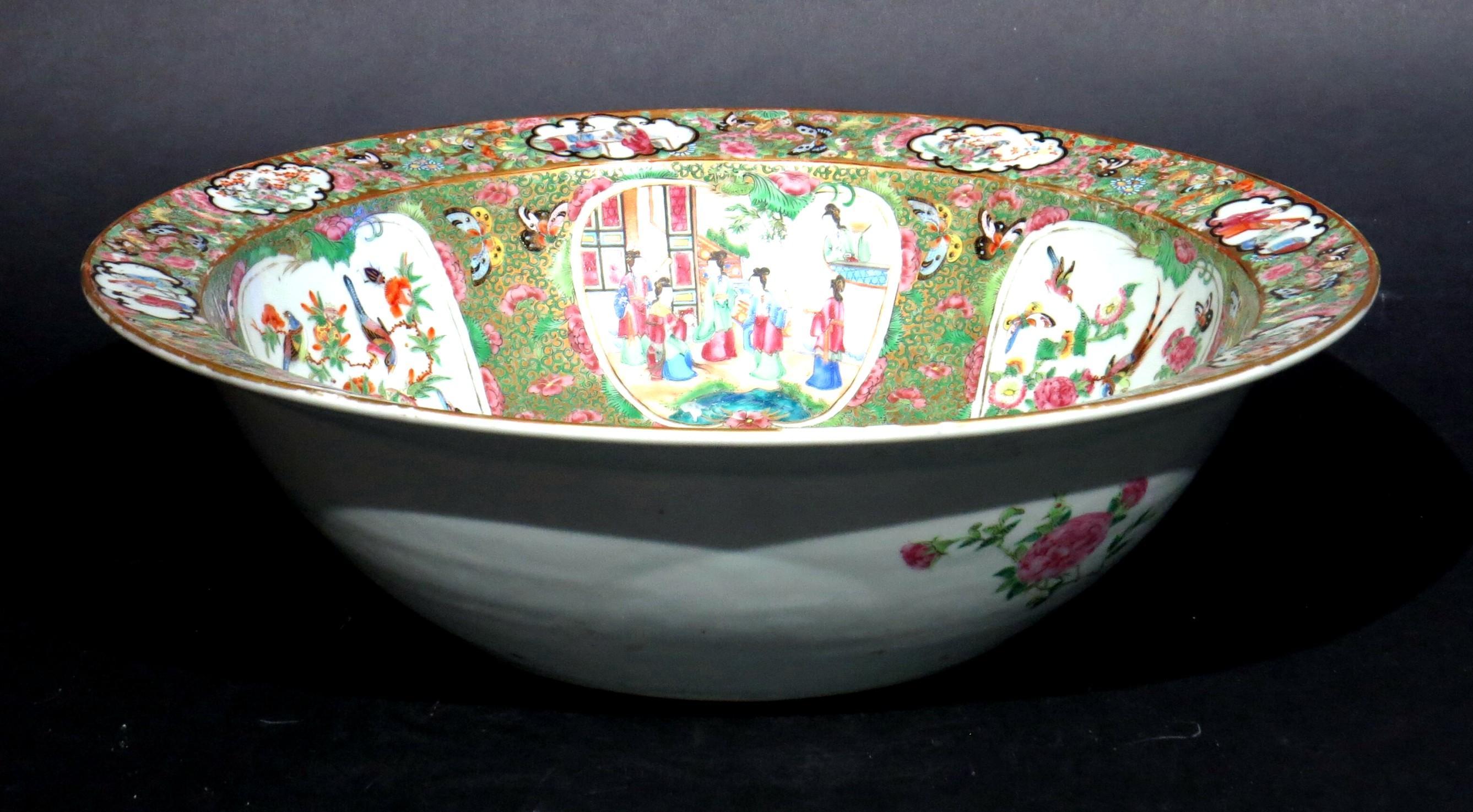 A large 19th century Chinese `Famille-Verte' Canton porcelain basin / punchbowl, decorated overall with hand painted enamels depicting courtly figures, surrounded by images of birds of paradise and assorted fauna & flora. 