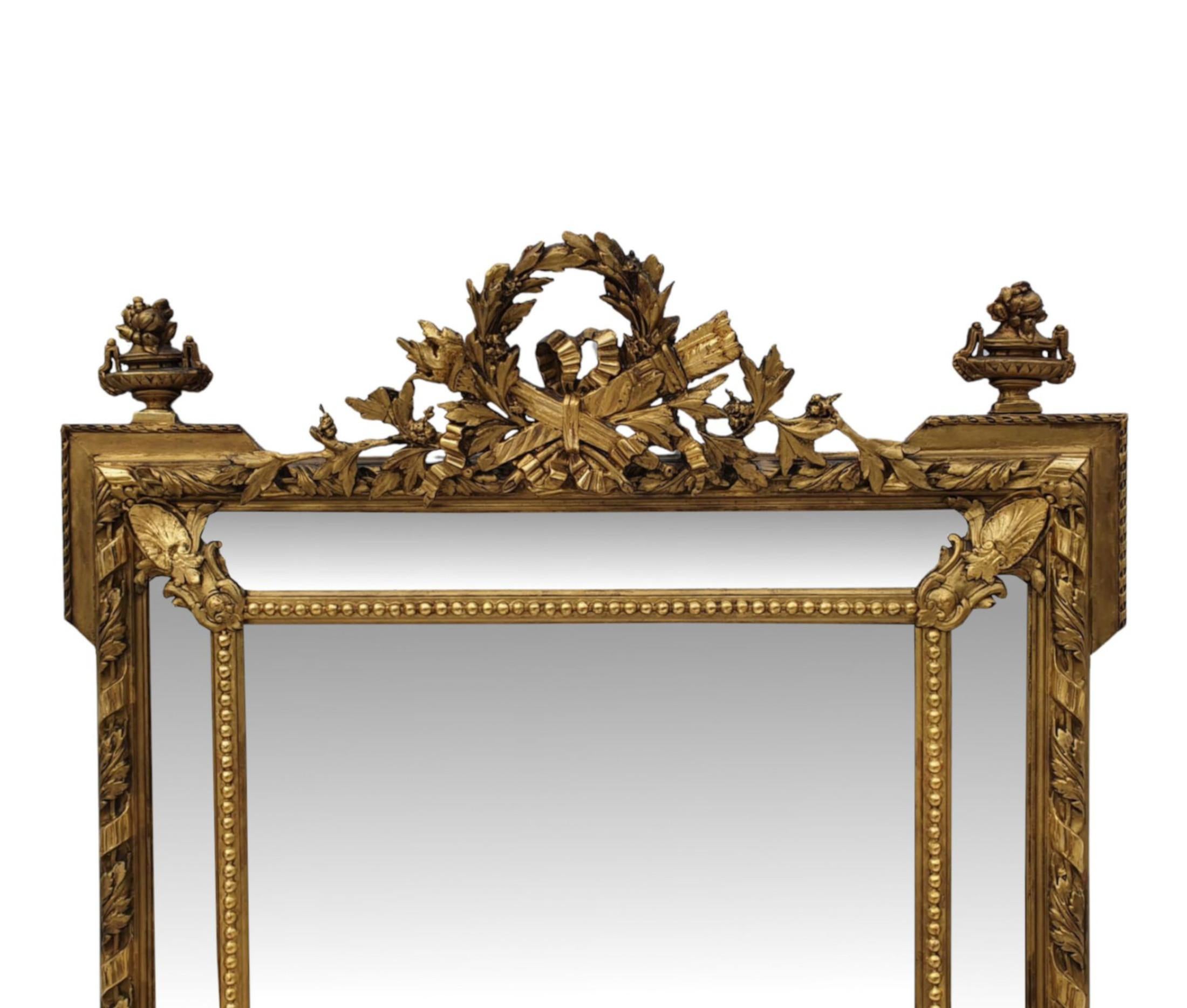 Très beau miroir d'entrée ou surmanteau en bois doré du 19ème siècle, de grandes proportions. La plaque de miroir de forme rectangulaire est placée dans un cadre en bois doré fabuleusement sculpté à la main, moulé et façonné, avec des détails de