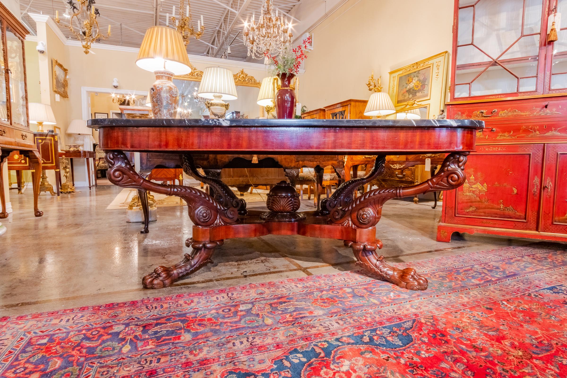 A very fine large 19th century English Regency mahogany and marble top center table. Carved heavy pawed feet and a center pedestal.