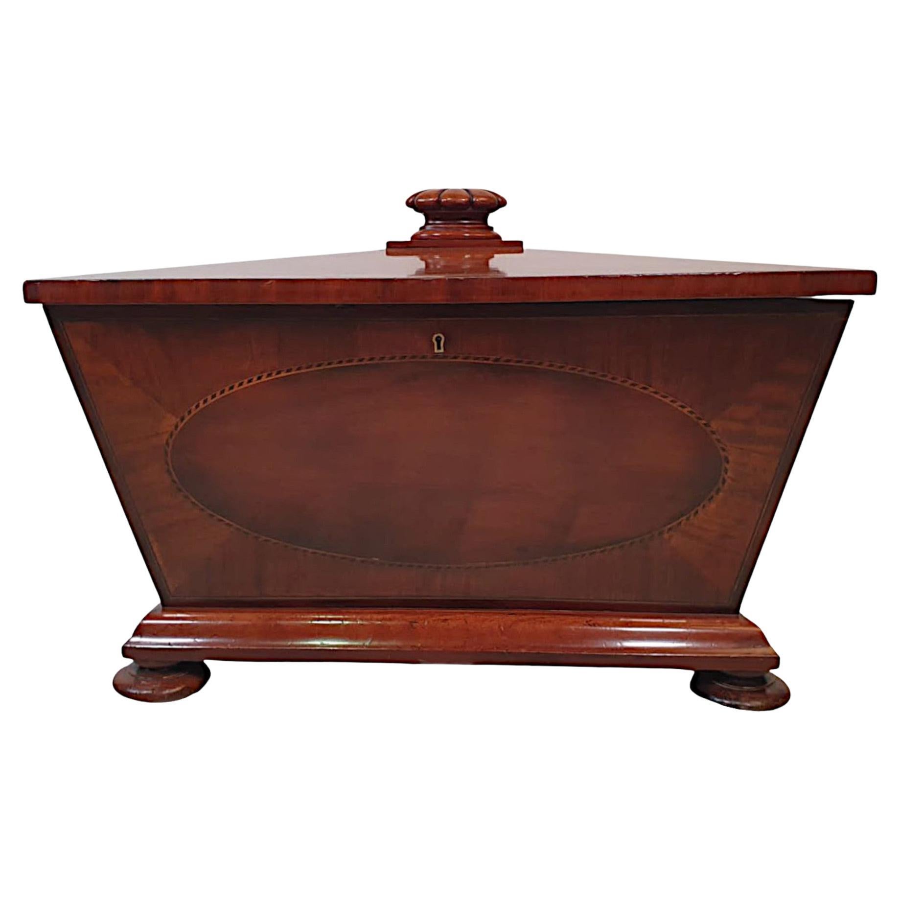 A very fine late 19th century beautifully figured mahogany sarcophogas shaped cellarette or wine cooler by Freeman's of Norwich. The hinged lid with gorgeous line inlay and a gadrooned finial handle, opening to reveal a fitted bottle holder section.