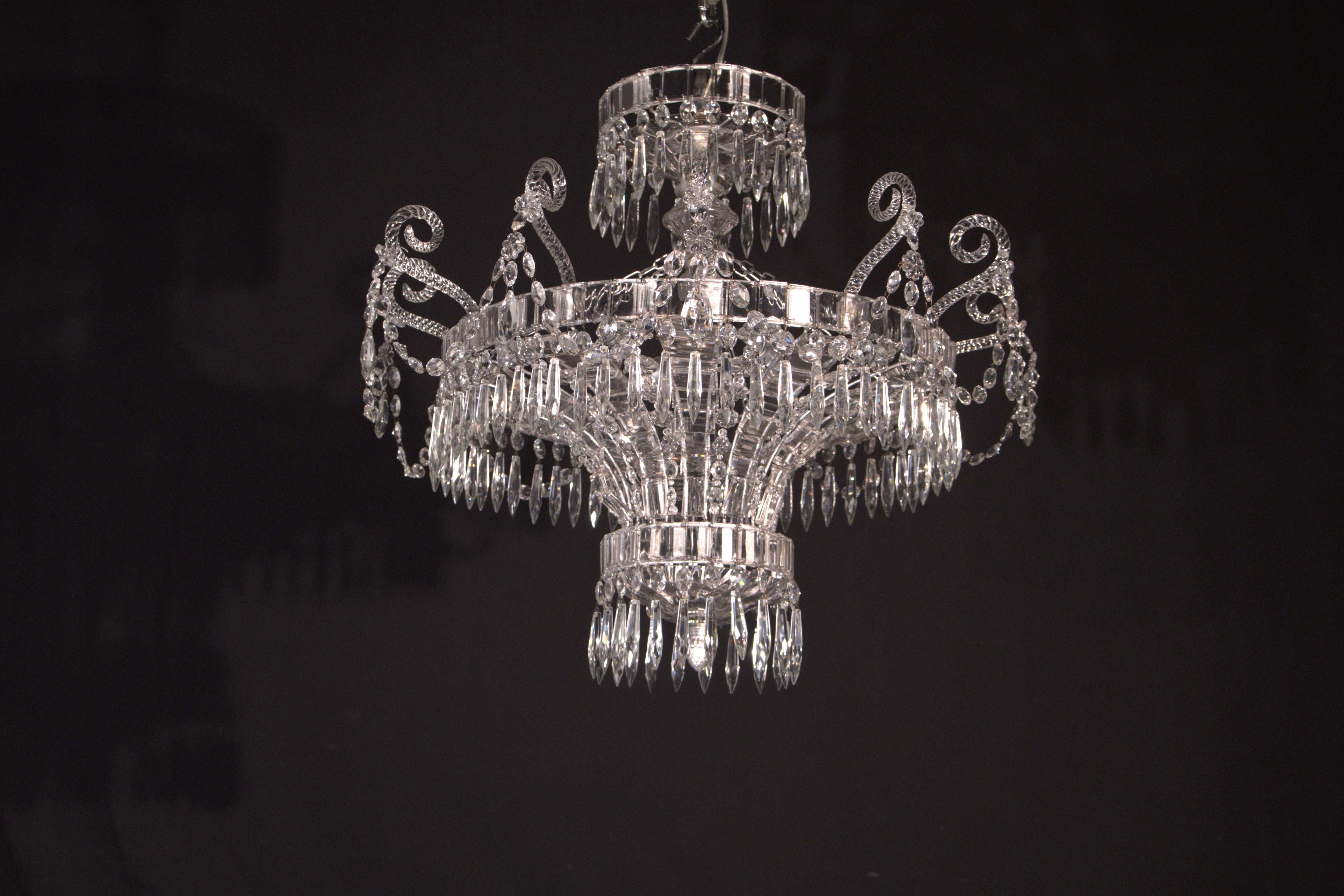 Un raffinato ed elegante lampadario in argento, bronzo e cristallo della Maison Bagues. Francia, 1930 circa. 3 luci. 
Dimensioni: Altezza 20 1/2