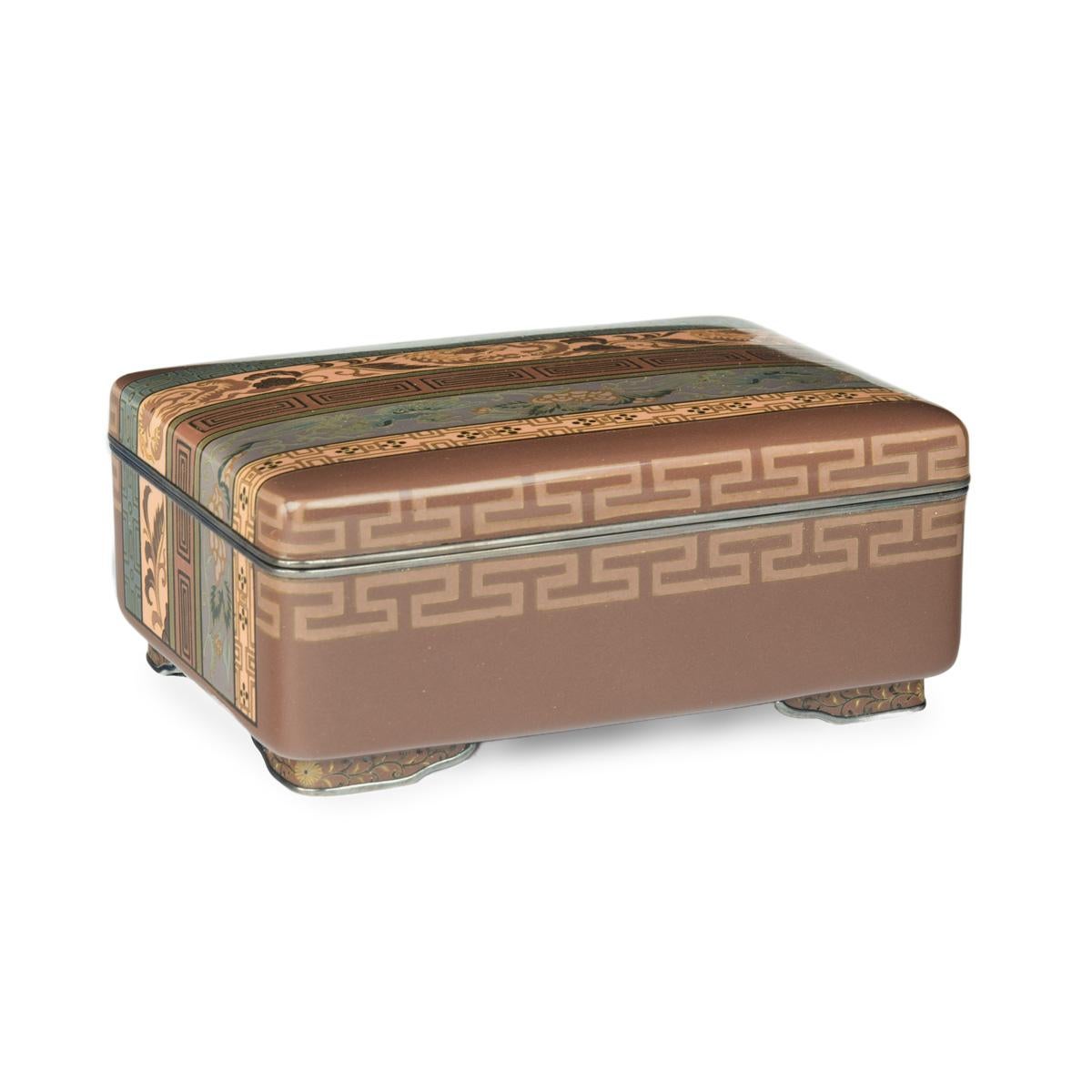 A very fine Meiji period cloisonné box and cover with brocade designs, by Hayashi Tanigoro, worked in silver wire and coloured enamels with geometric and stylised dragon and phoenix bands, reserved against a mocha-ground, raised on four decorated