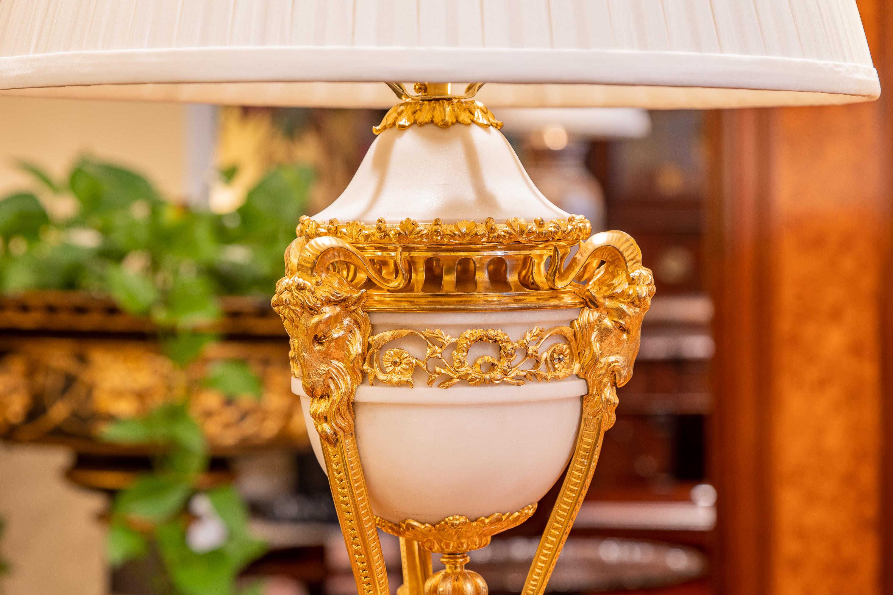 A very fine pair of French Louis XVI Carrera marble and gilt bronze tripod lamps. Mercury gilt.
