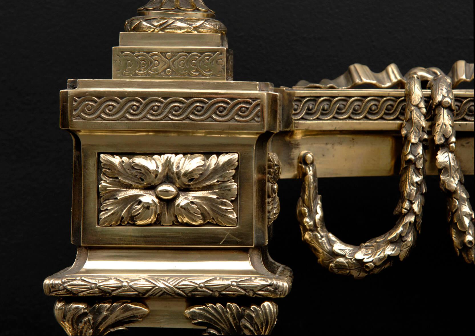 Pair of the finest quality early 19th century Louis XVI brass chenets. The base with lions feet and moulded relief design. Three acanthus leaf paterae with guilloche moulding. Impressive urns with swags and fluted stems, cherubs to sides, and