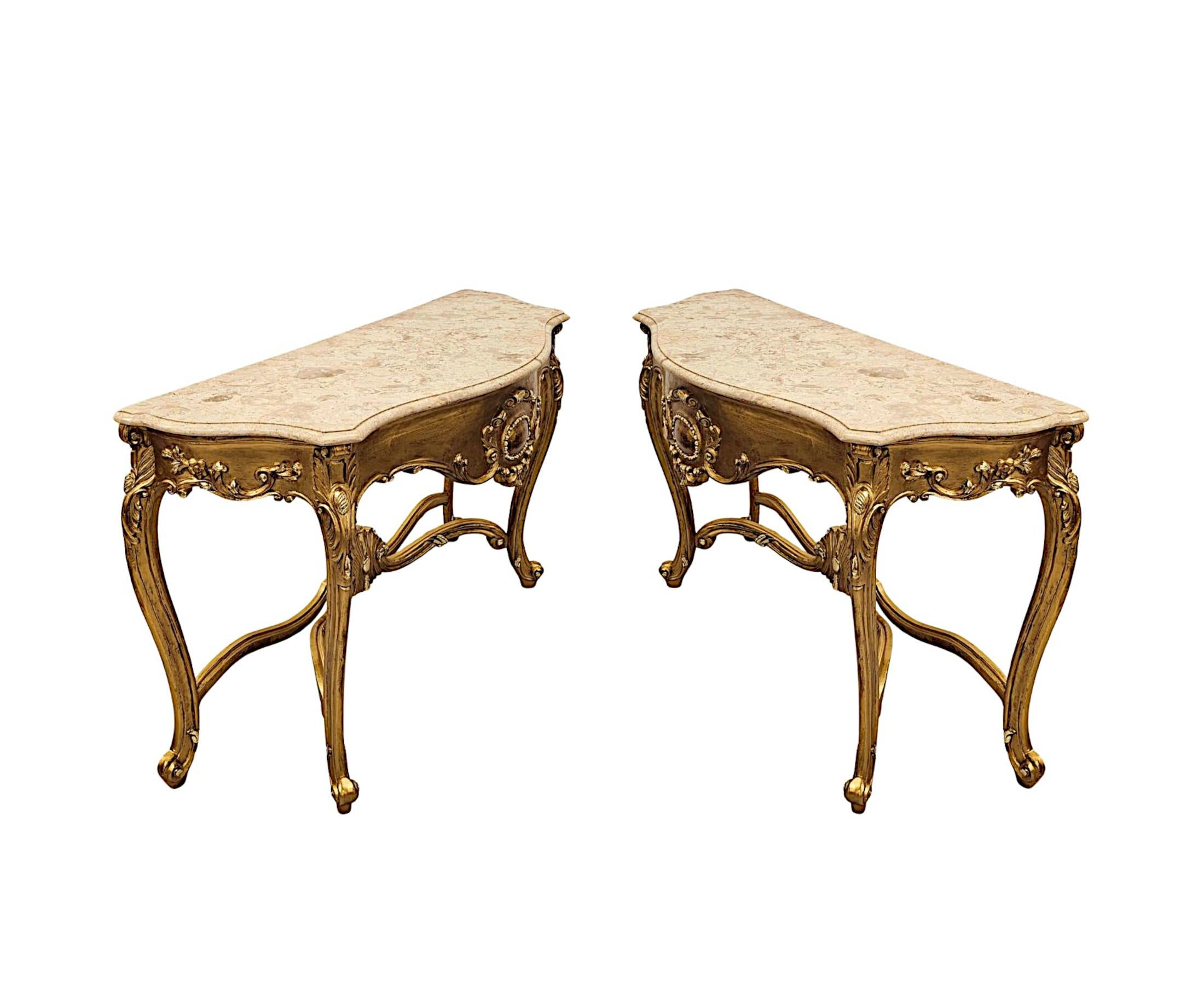 A very fine pair of early 20th Century marble top giltwood console tables, superbly hand carved and of exceptional quality. The gorgeous, moulded cream and gold Calcutta serpentine marble top of rectangular form with canted corners is raised over