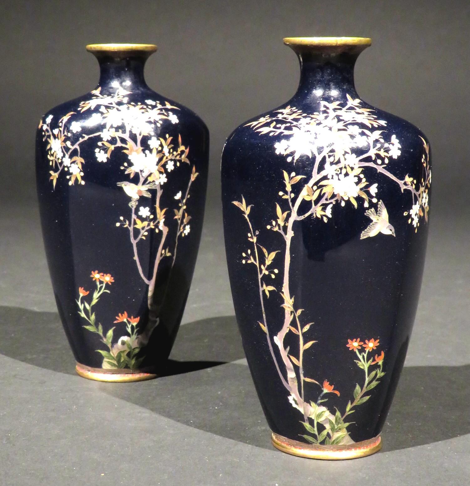 Both hexagonal panelled bodies exquisitely decorated by hand with multi-coloured enamels, illustrating directionally opposing vignettes of songbirds perched among flowering prunus against a deep indigo blue field.
The level of craftsmanship and