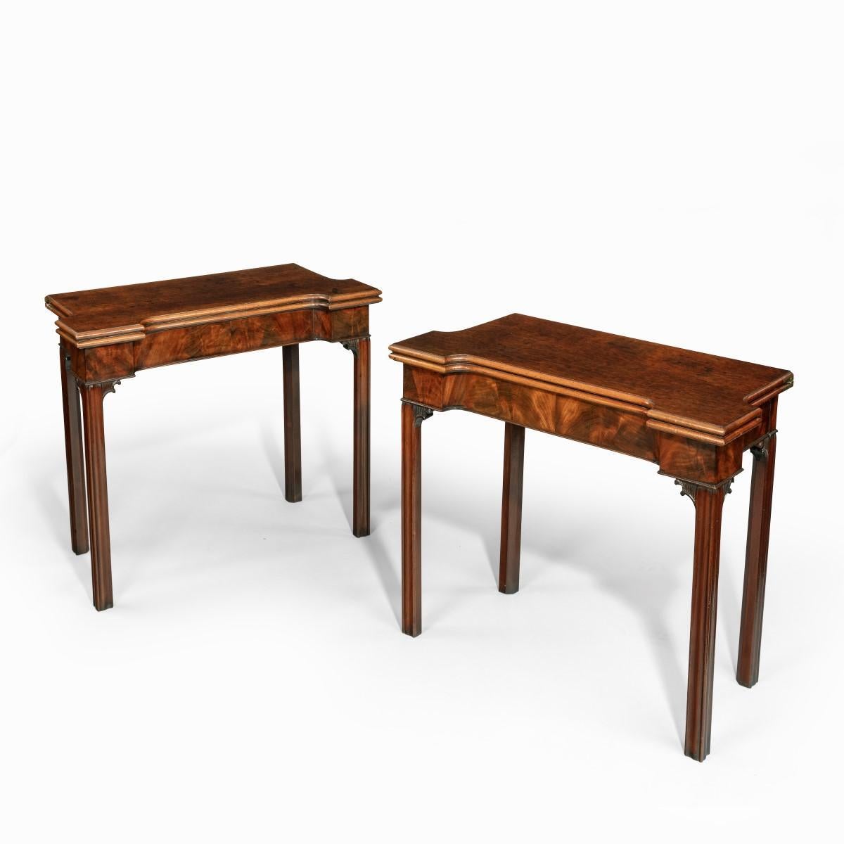 A very fine pair of George III mahogany and plum pudding mahogany concertina action card tables, each with square cut corners and recessed sides, the hinged tops opening to reveal a baize lined interior with counter recesses and candle stands, one