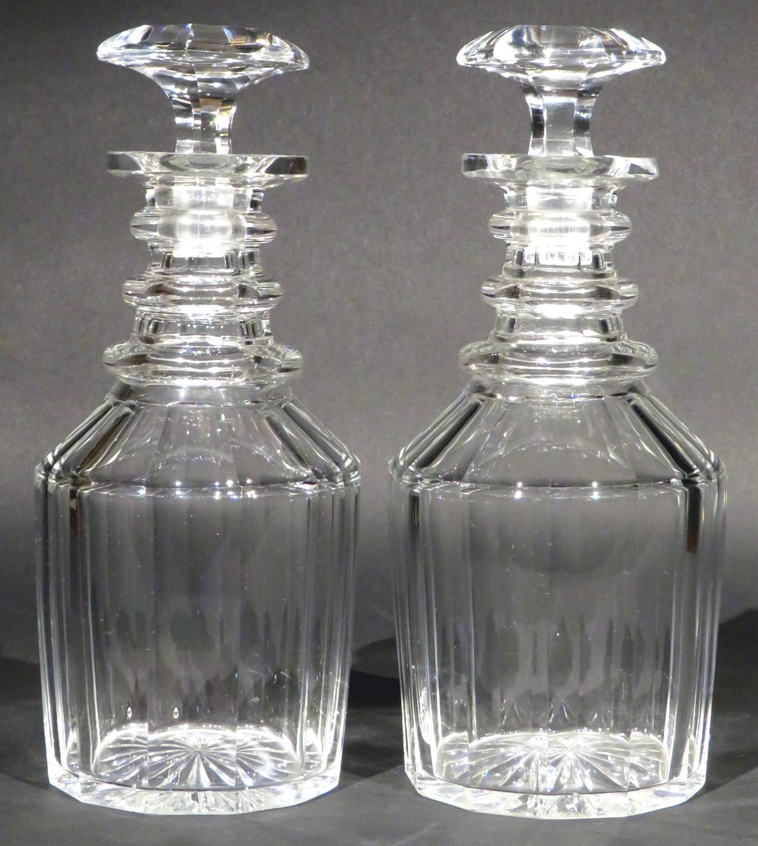 Both decanters of mallet form with panel-faceted shoulders and bodies, rising to triple-ringed necks fitted with their original dedicated and hexagonal shaped stoppers, the undersides of each base engraved with radiating star-cut motifs. Both in