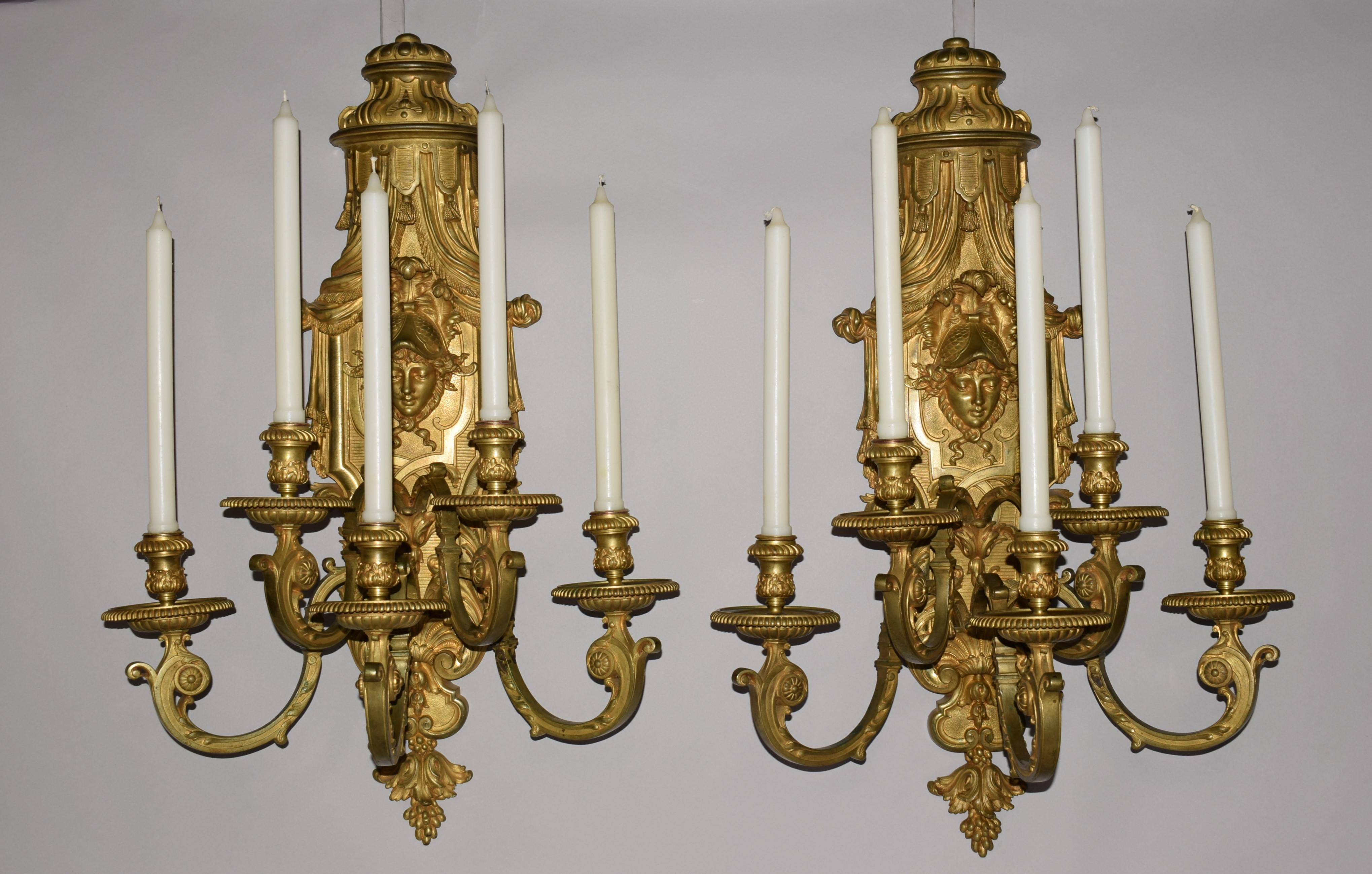 A superb pair of gilt bronze regency style wall sconces. The back plate depicting Athena wearing a helmet with petals issuing 