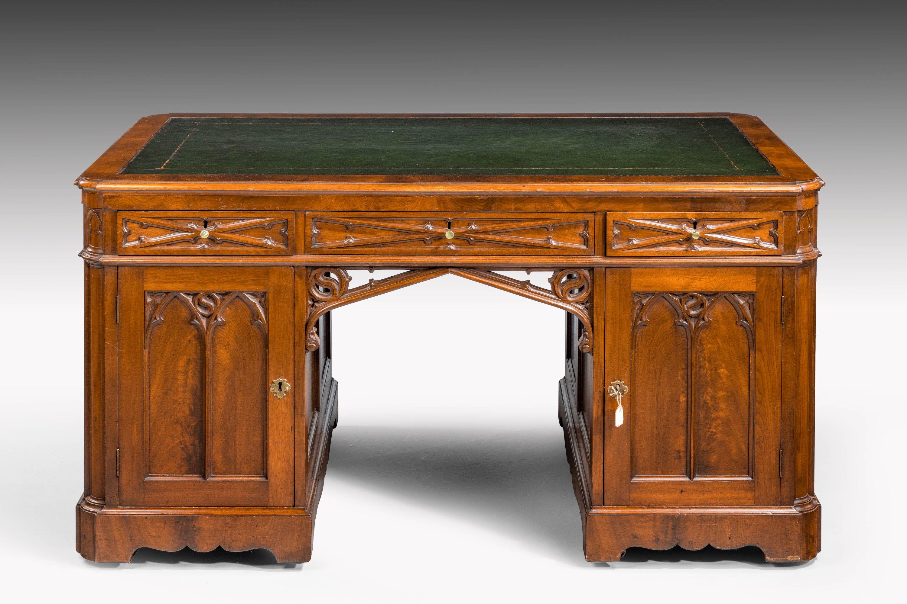 A very fine quality and well-carved, Gothic, mahogany desk. With elaborate and well-executed carving to all the show surfaces. Draws to one side with reverse cupboards and drawers to the other.
 