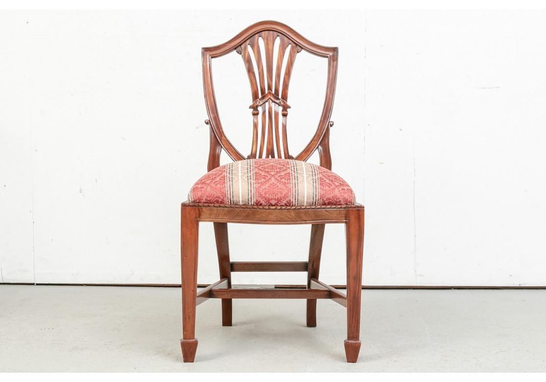 A large and very well made set of Classic Mahogany Shield-Back Dining Chairs . With handsome softly grained wood, and a well-formed Frame with Classic Shield back with Stylized Back Splat, H-Form Stretcher, Tapered Block Feet and Rope Carving Trim