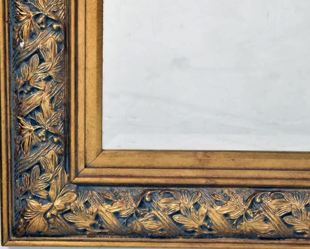 A Florentine Renaissance revival gilded mirror, finely carved, illustrating a variety of botanical subjects.