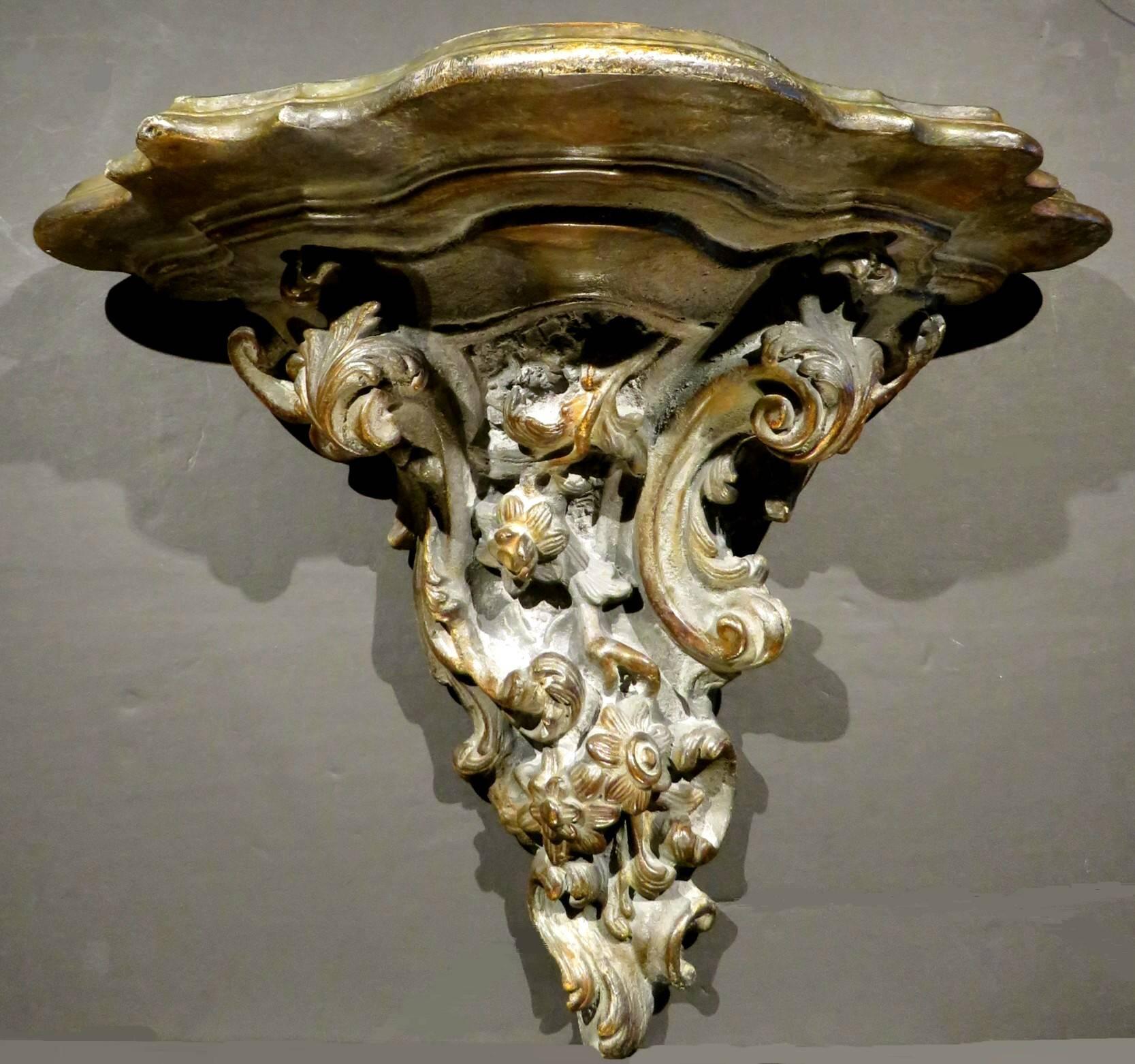 A very substantial and fine 18th century Rococo period wall bracket, showing a trefoil shaped plateau above a robust grouping of organic elements composed of leafy vines, flower-heads and 'C' scrolls in high relief, the surface exhibiting an
