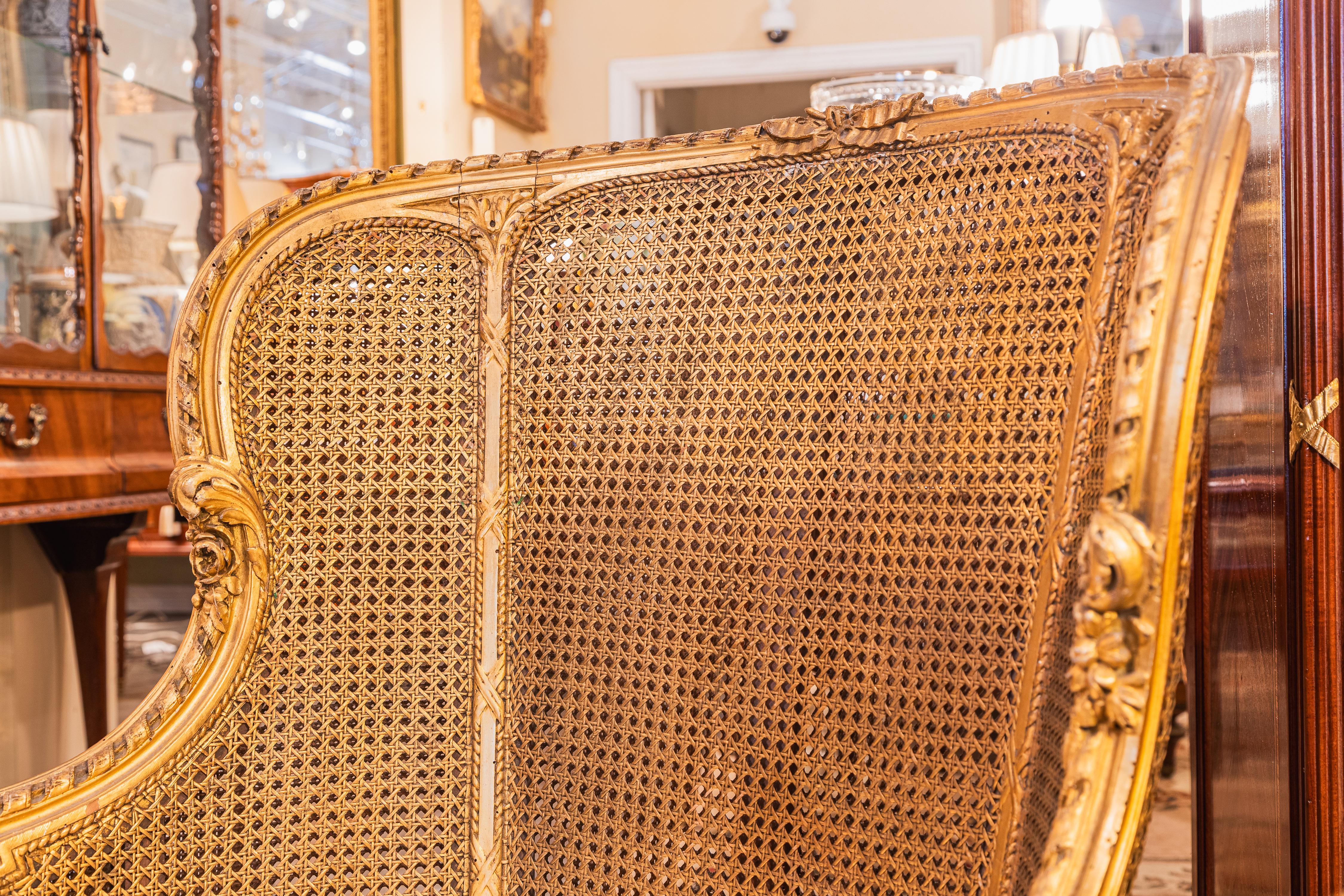 Très bonne bergère du XIXe siècle de style Louis XVI, sculptée de cannes et de dorures. Bon état - En vente à Dallas, TX