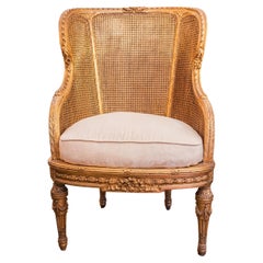 Très bonne bergère du XIXe siècle de style Louis XVI, sculptée de cannes et de dorures.